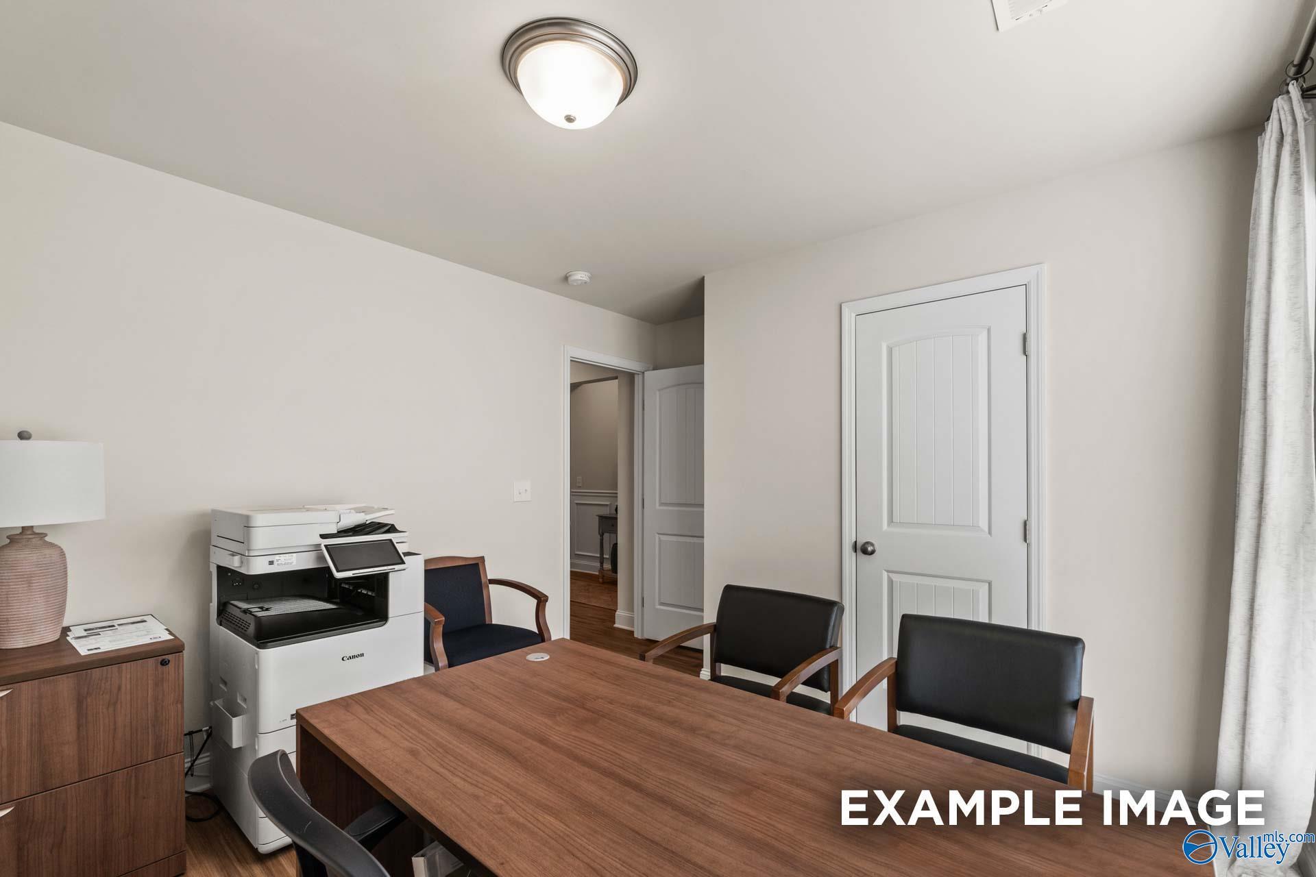 Cozy home office with wooden desk, leather chairs, printer, and beige walls in Davidson Homes Franklin C, New Market, Alabama
