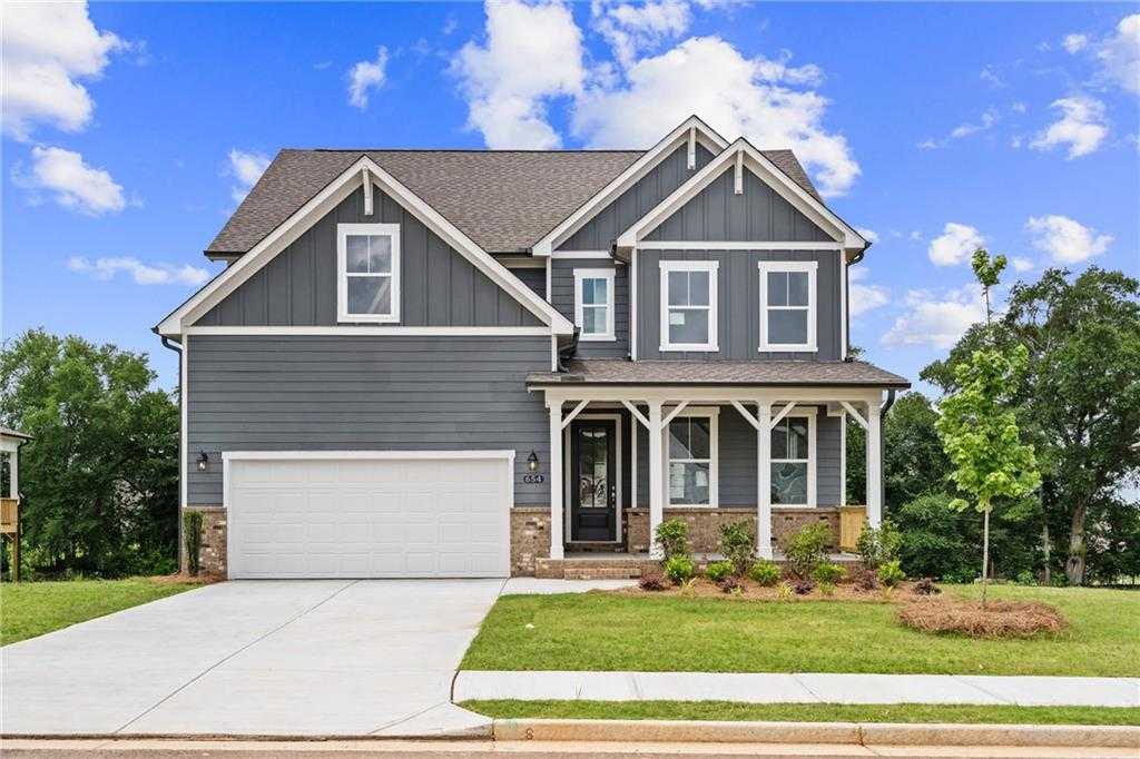 Modern gray craftsman 4-bedroom home with 2-car garage, front porch, and landscaped yard in Wehunt Meadows, Hoschton, Georgia