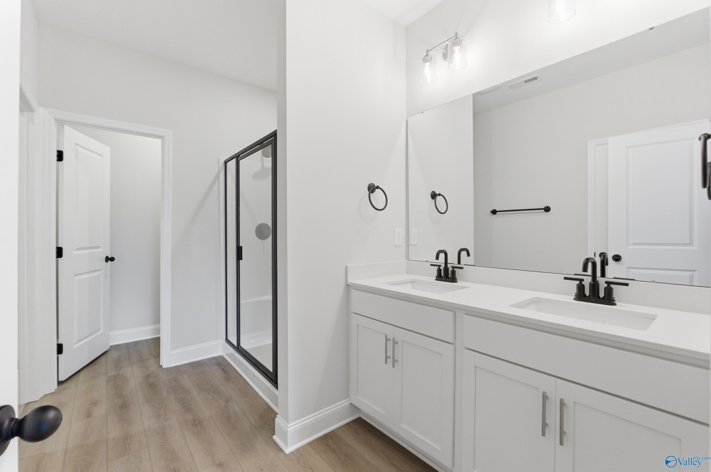 Modern master bathroom with double vanity, frameless glass shower, white cabinetry in Davidson Homes The Daphne C, Huntsville, AL