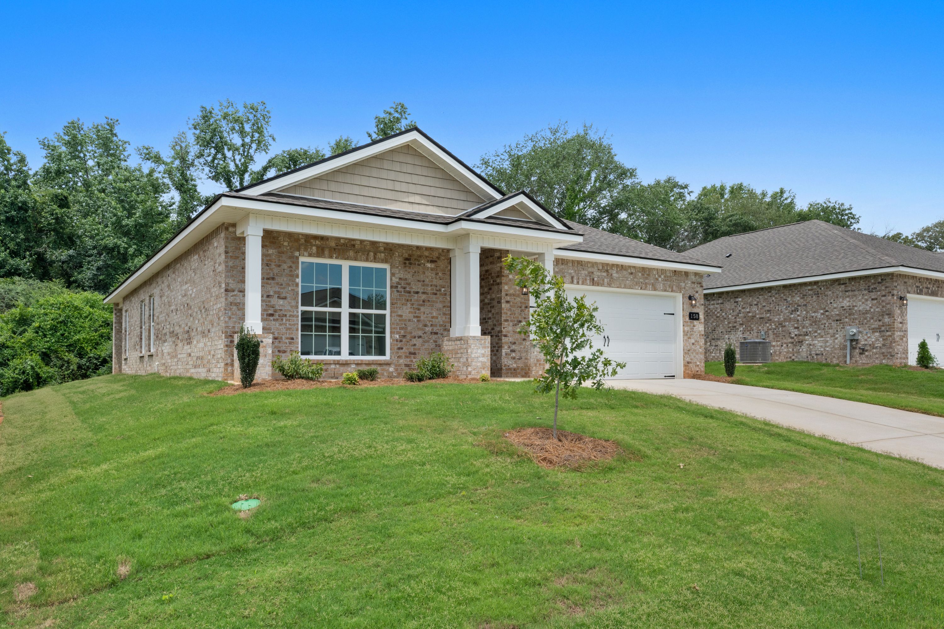 Single-story brick home exterior by Davidson Homes at Flint Meadows in New Market, Alabama with a covered front porch.