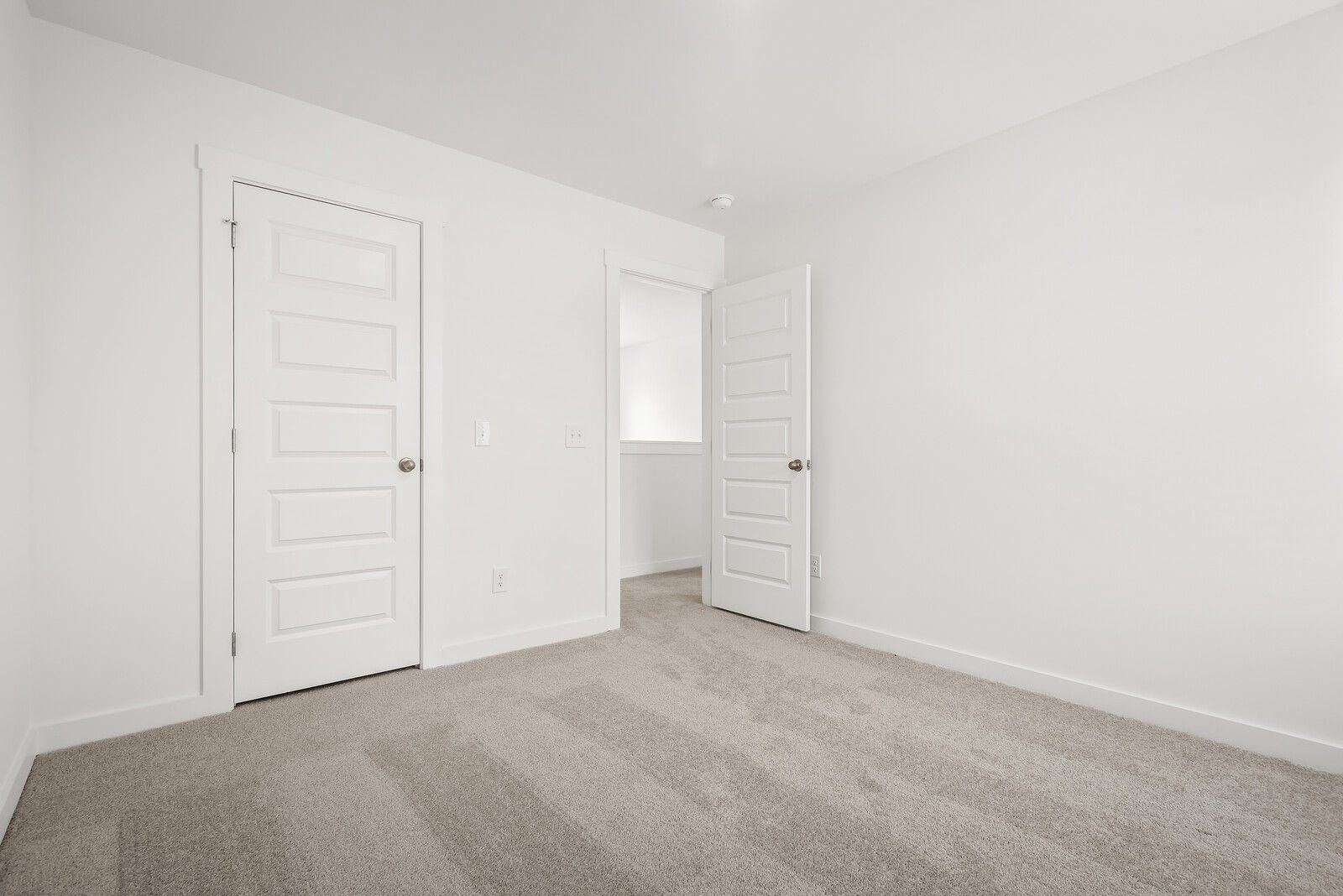 Bright master bedroom with open closet and bathroom doors on beige carpet in Davidson Homes The Gordon C, White House, TN
