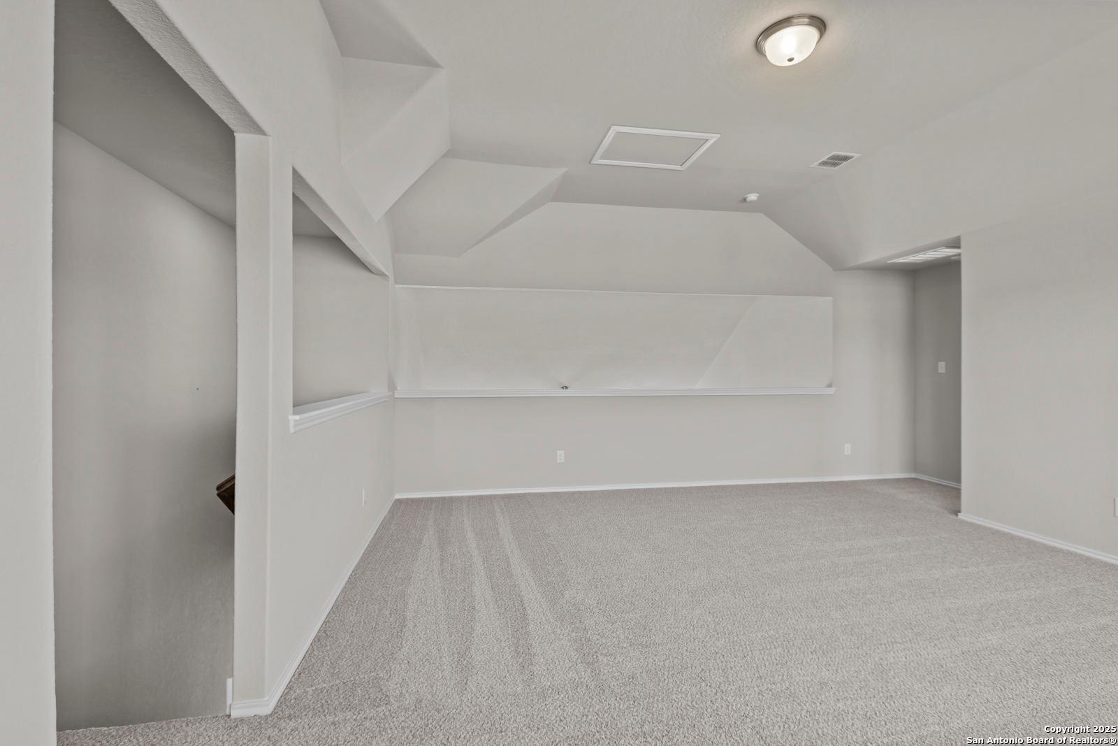 Vaulted ceiling flex room with built-in shelves, carpet floor, and recessed lighting in Davidson Homes The Collin B, Seguin, Texas