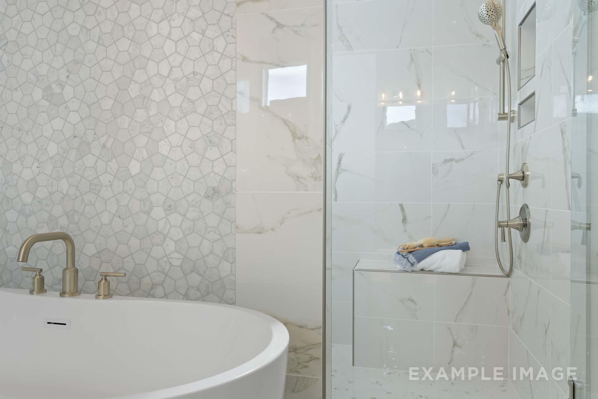 Luxurious master bathroom in The Seaside C with freestanding tub, marble shower enclosure, hexagonal tile accents