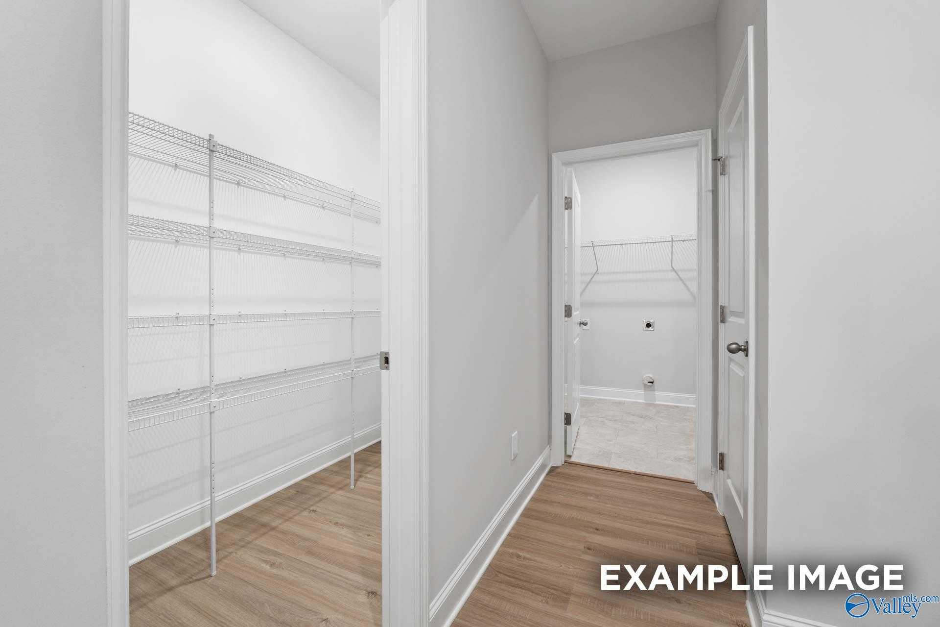 Spacious walk-in pantry with wire shelving beside laundry room in Davidson Homes The Lanier, Meridianville, Alabama