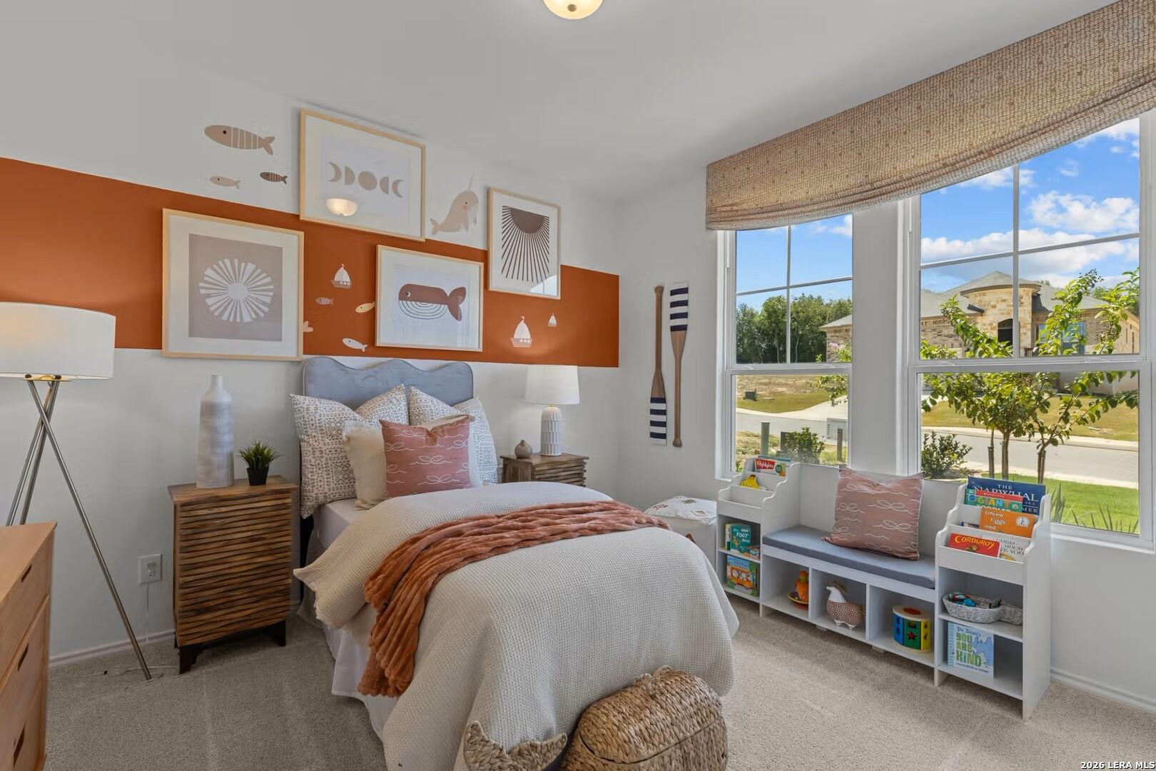 Cozy child's bedroom with nautical art, orange accent wall, and reading nook in The Daphne K, Bricewood, San Antonio, Texas