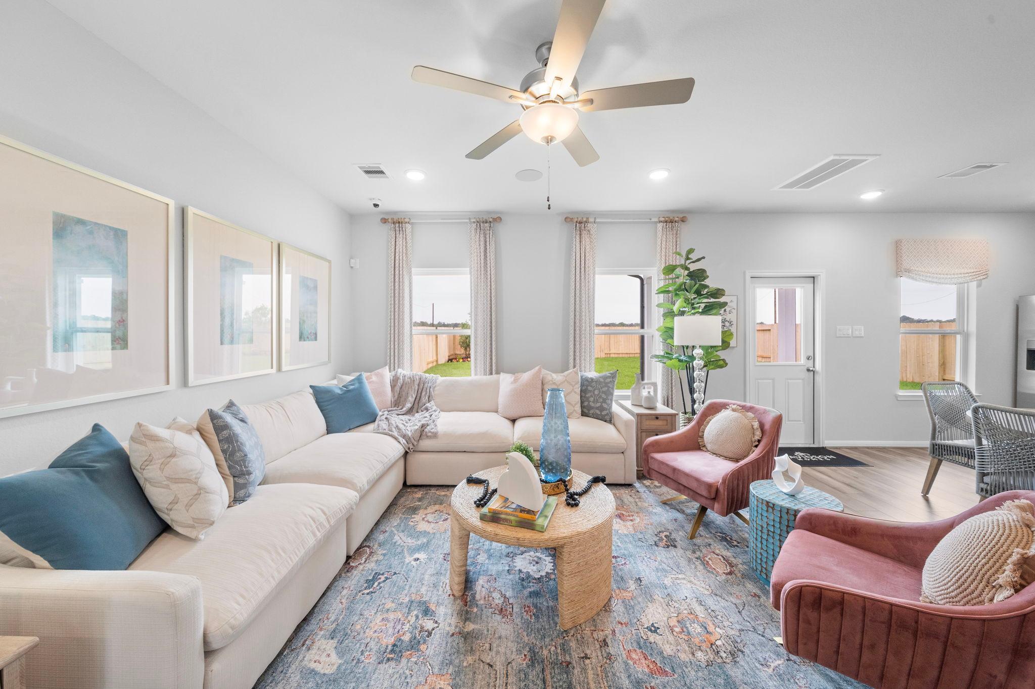 Spacious living room at Spring Branch Crossing in Conroe TX by Davidson Homes featuring beige sectional sofa, accent chairs, and abstract art