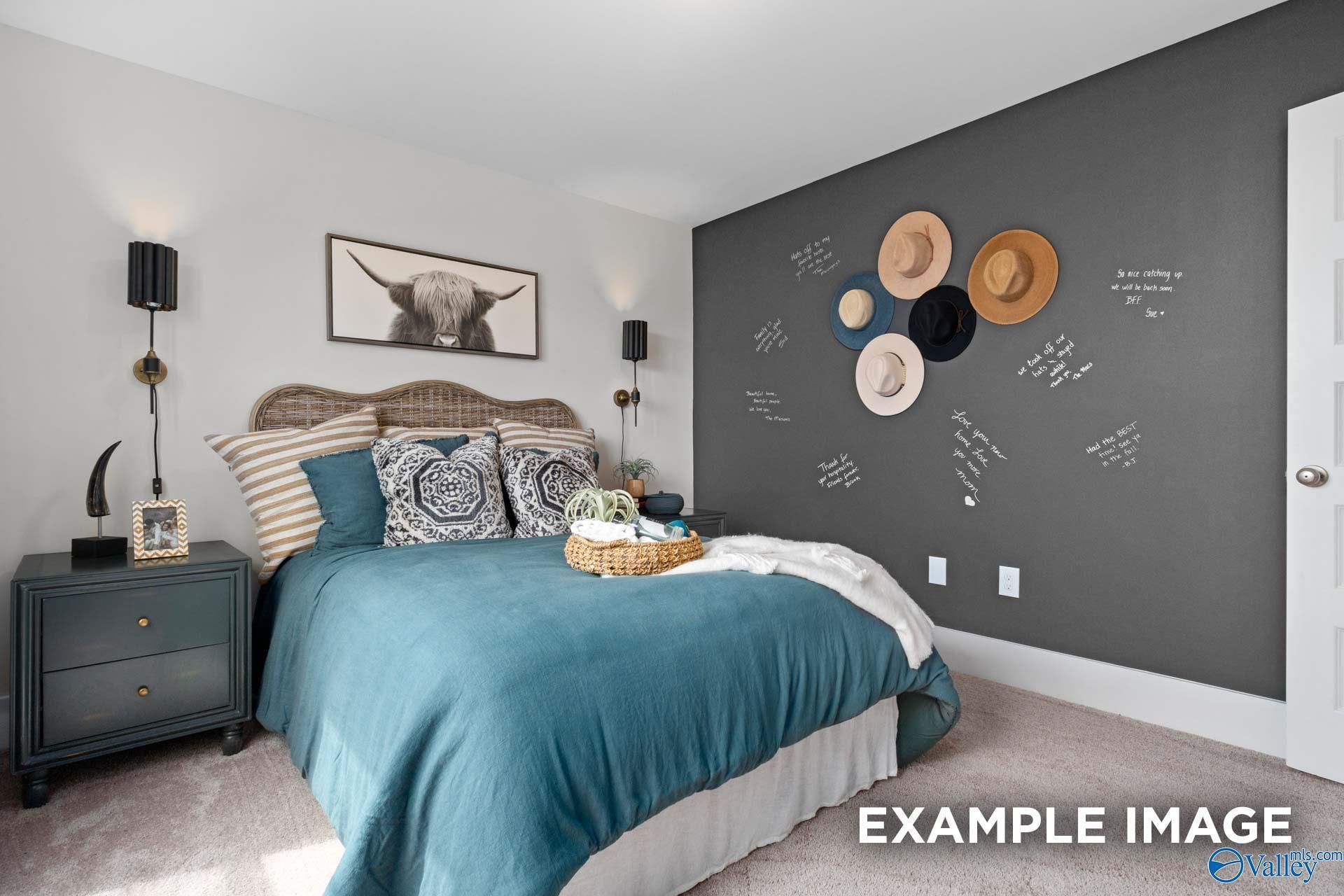 Cozy bedroom with teal bedding, rattan headboard, and chalkboard accent wall in Davidson Homes Chelsea A, Ivy Hills, Toney Alabama