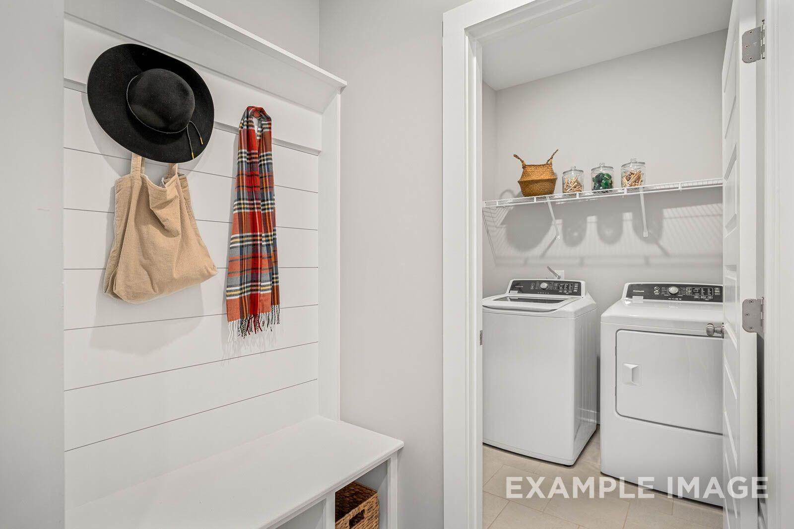 Mudroom with coat hooks, plaid scarf, tote bag, bench, and adjacent laundry room featuring washer dryer in Davidson Homes The Franklin B, White House, TN