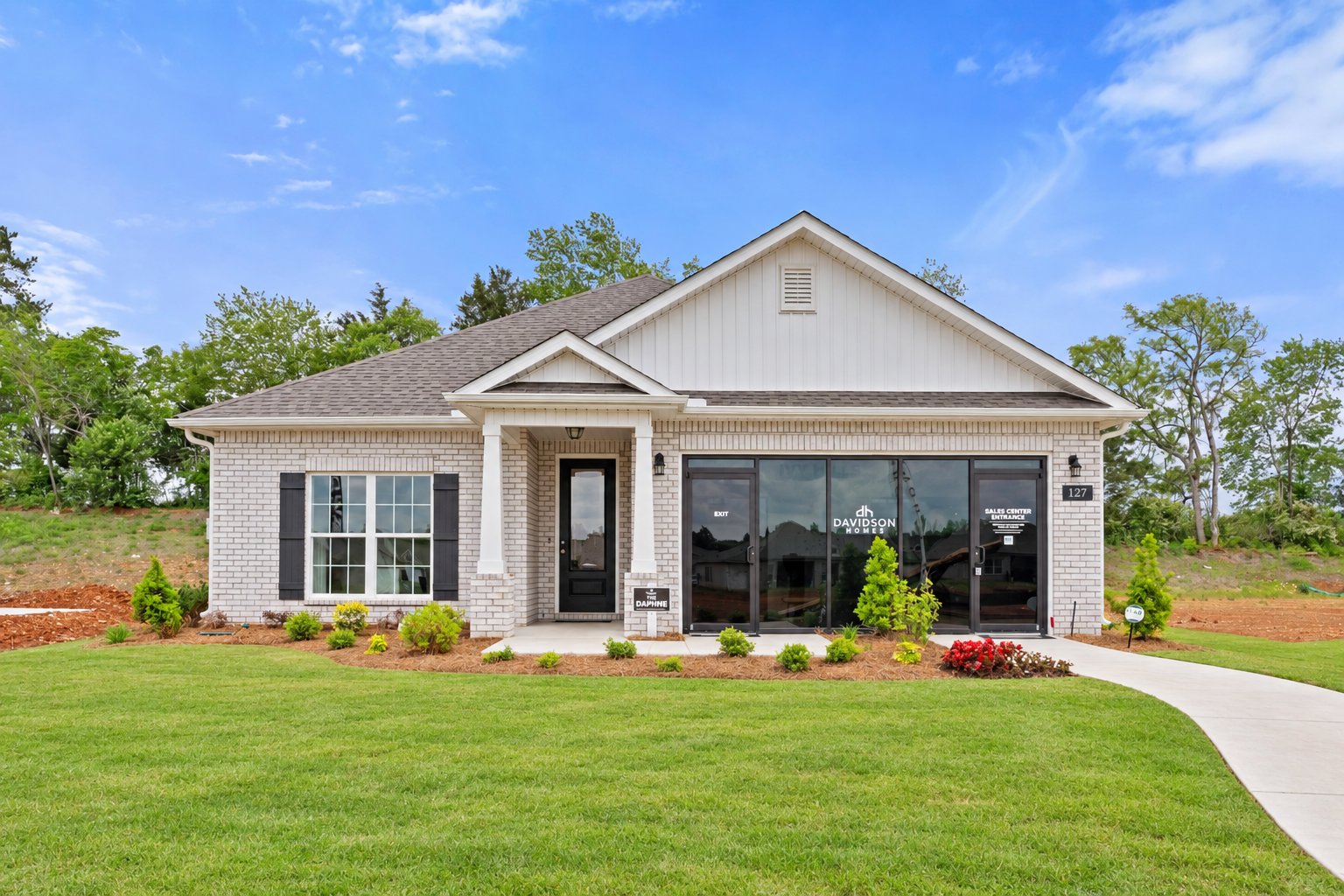 Modern sales center at Ivy Hills in Toney Alabama by Davidson Homes with brick accents large windows and landscaped yard