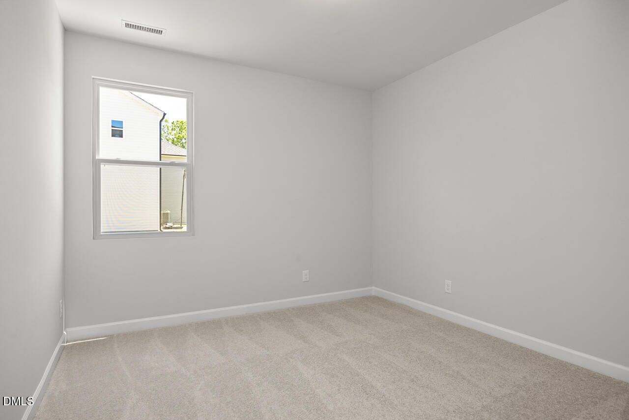 Bright, spacious bedroom with plush carpeting in The Adalynn A floor plan at Gregory Village in Lillington, North Carolina.