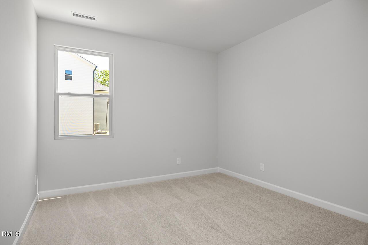 Bright, spacious bedroom with plush carpeting in The Adalynn A floor plan at Gregory Village in Lillington, North Carolina.