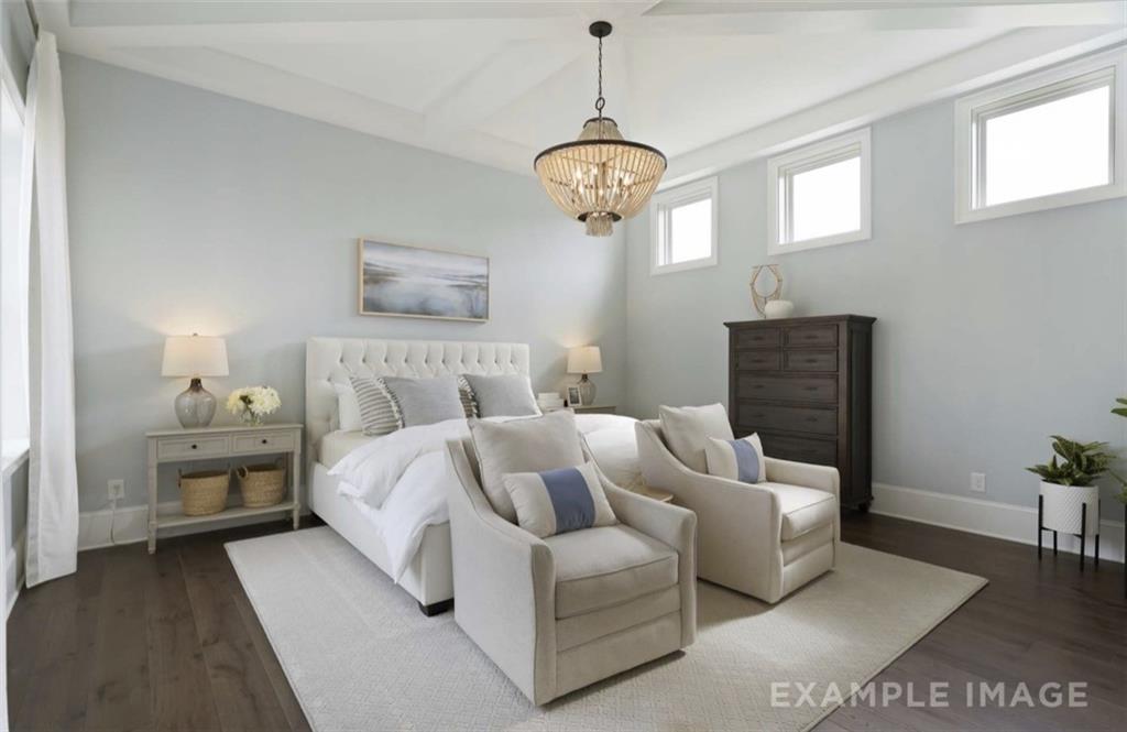 Elegant master bedroom with tufted king bed, beige armchairs, chandelier, and clerestory windows in Davidson Homes Seaside A, Woodstock GA