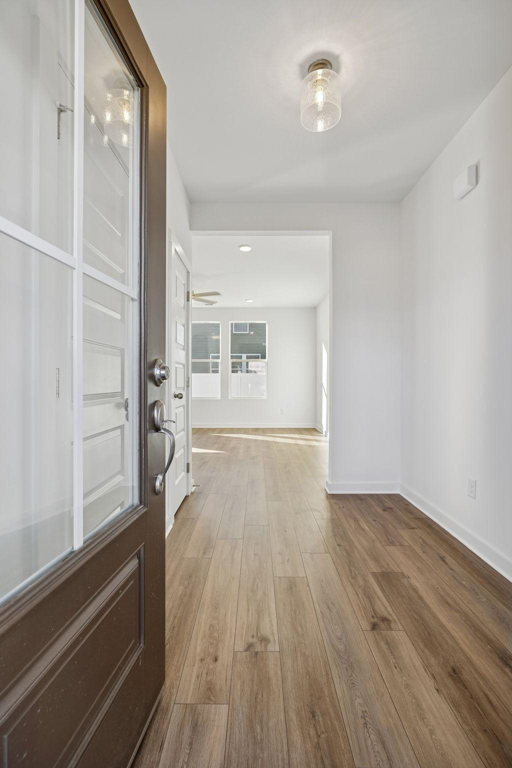 Inviting foyer entrance with open glass-paneled door and light hardwood floors in Davidson Homes The Gordon B, White House, TN