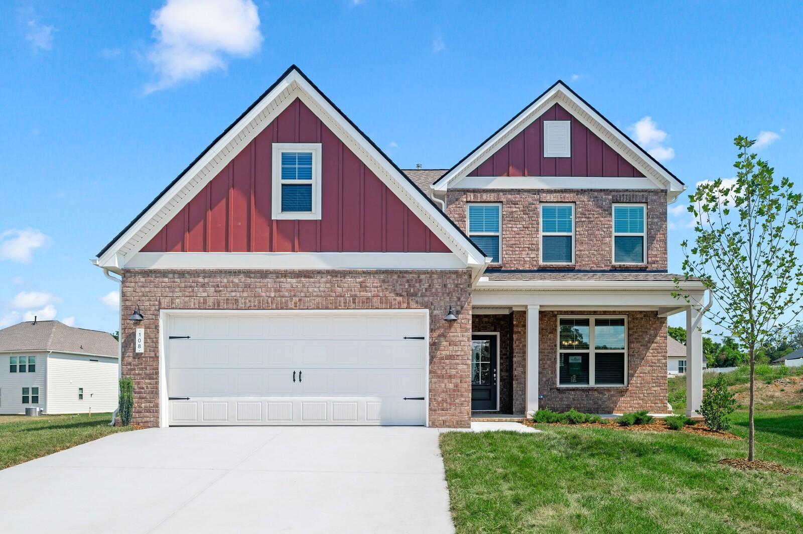 Two-story brick home with red siding and two-car garage, The Ash A floor plan in Woods Crossing, Gallatin, Tennessee.