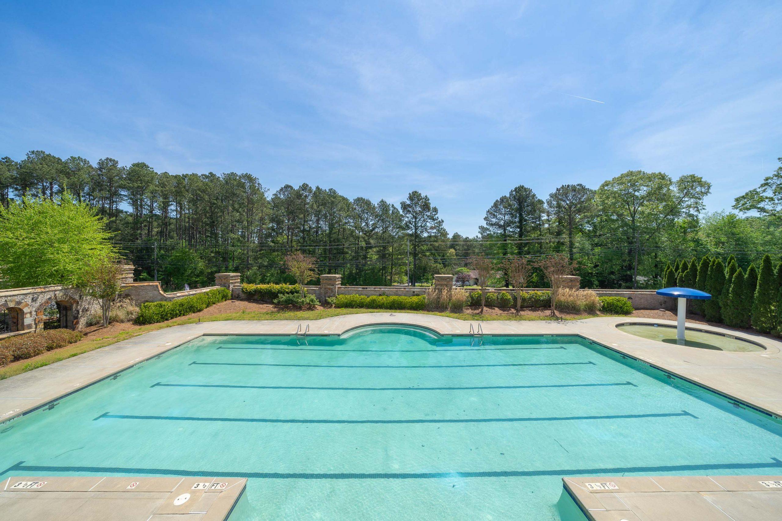 Community swimming pool at Mountainbrook in Cartersville GA with lap lanes, stone entrance, and surrounding pines