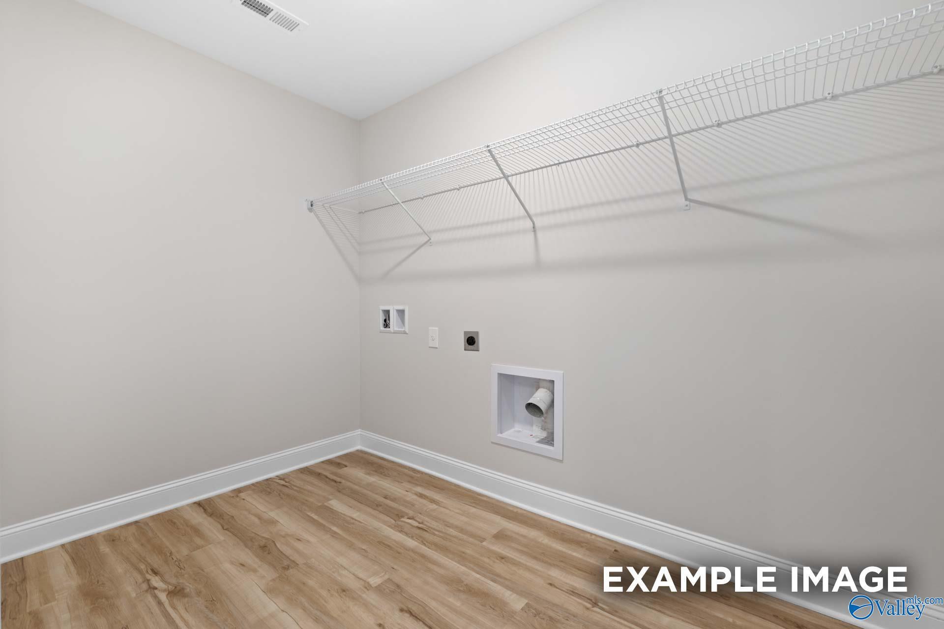 Laundry room with wire shelving and utility hookups in The Shelby B floor plan at Jaguar Hills, Huntsville, Alabama.