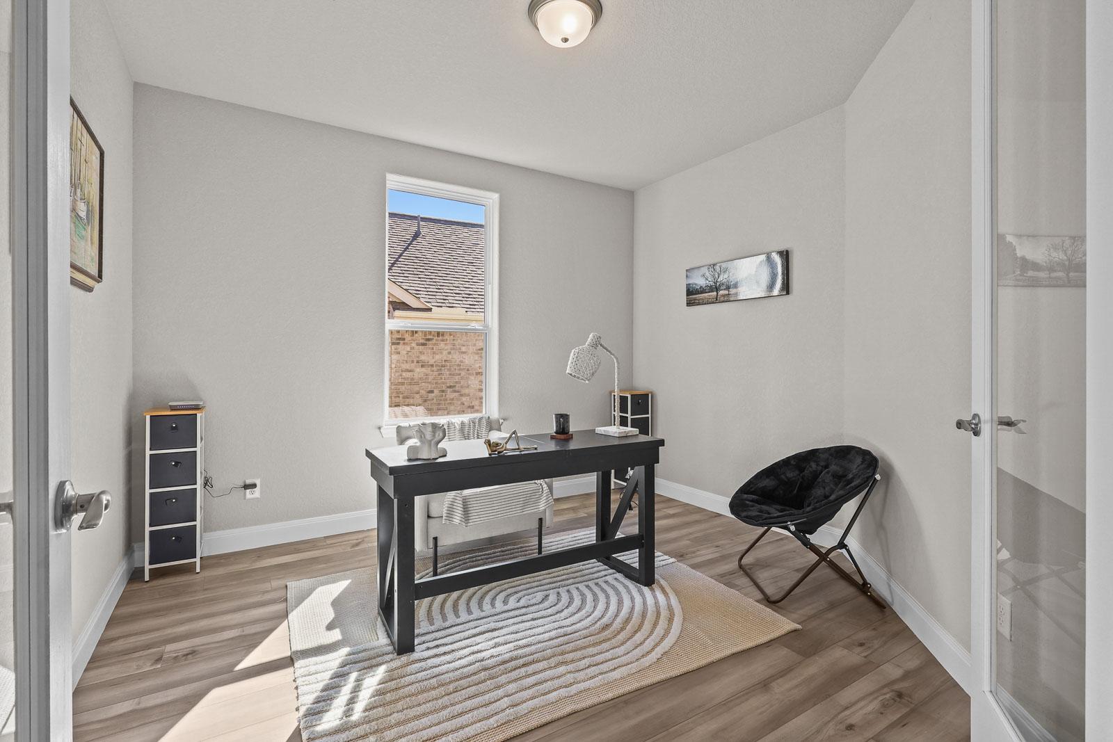Bright home office in The Jennings G featuring a modern desk, sleek flooring, and natural light in Castroville, Texas.