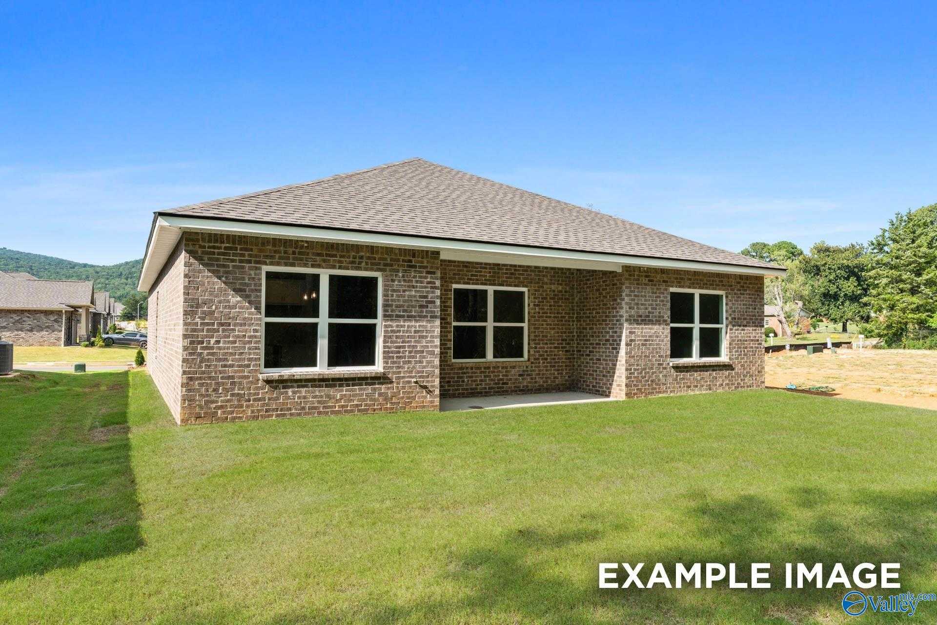 Single-story brick ranch home with gabled roof, large windows, and covered porch on lush lawn in Blue Spring, Huntsville, Alabama - Davidson Homes The Asheville C