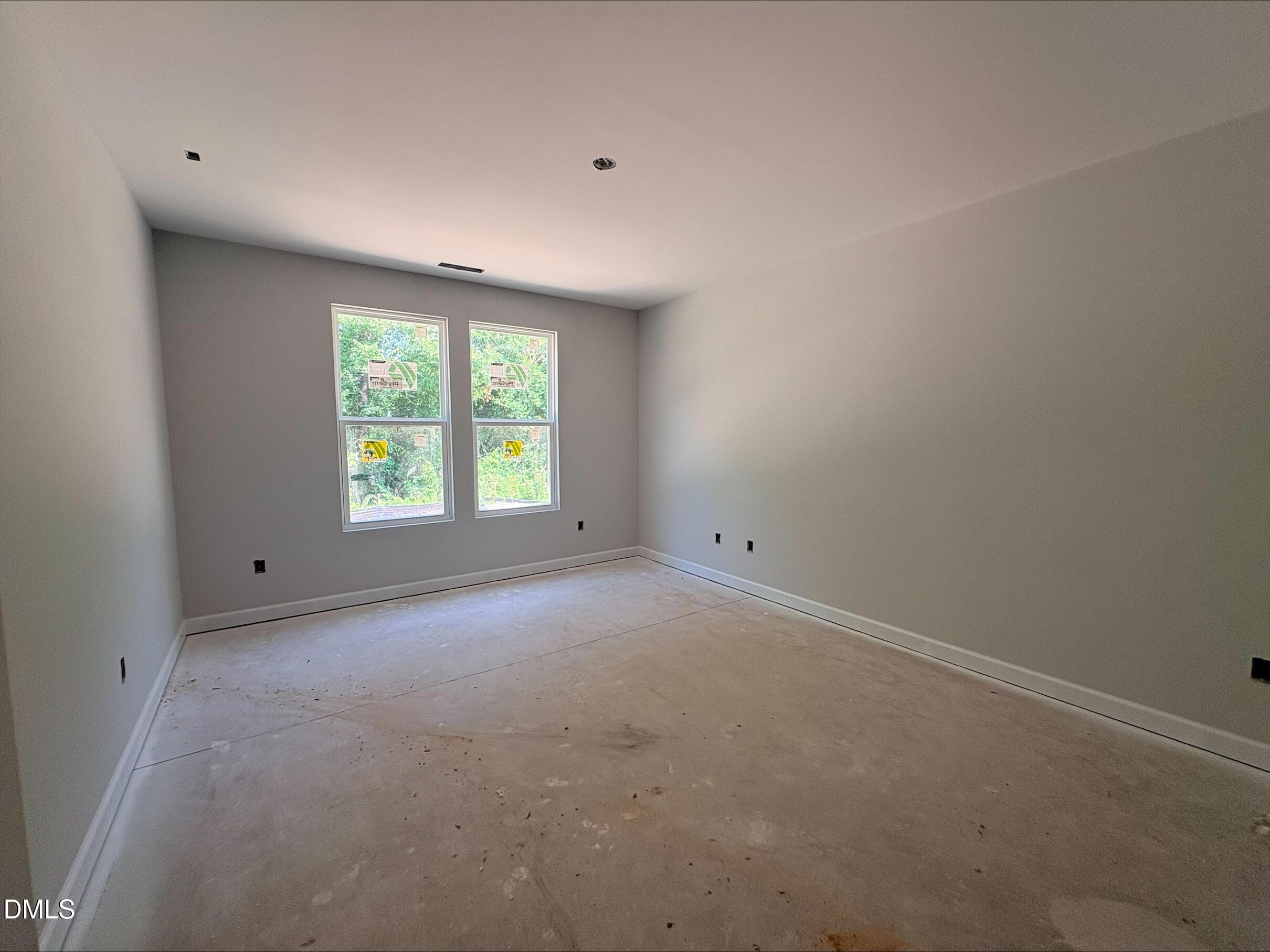 Unfinished bedroom with grey walls and large windows in The Daphne D floor plan at Woodland Crossing, Zebulon, NC.