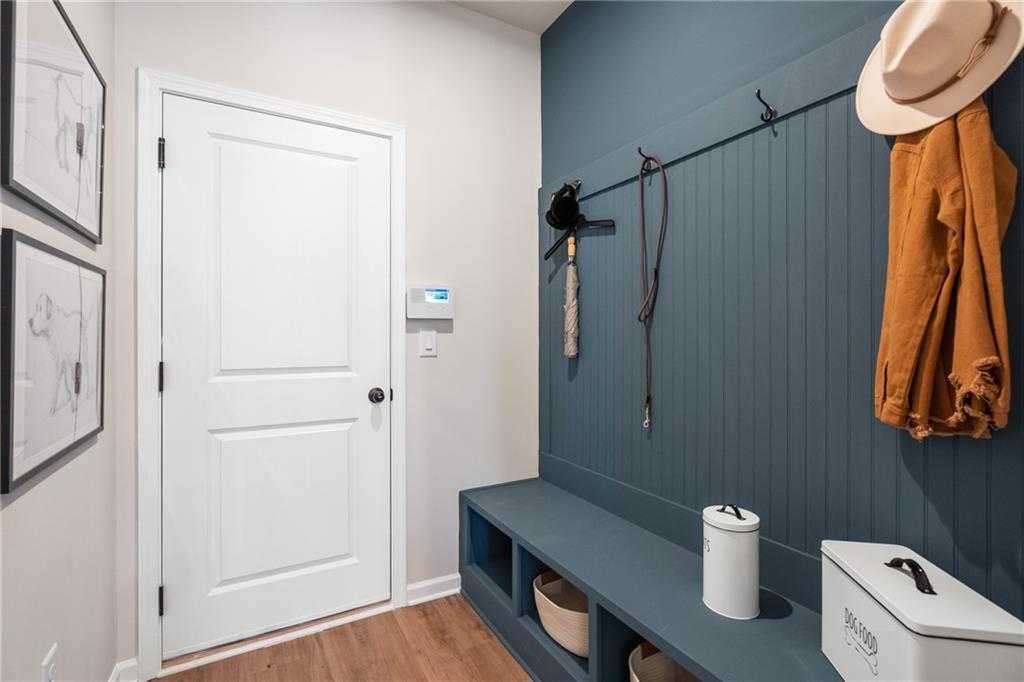 Navy shiplap mudroom with built-in bench, coat hooks, hat, leash, storage cubbies in Davidson Homes The Marion C, Winder, Georgia