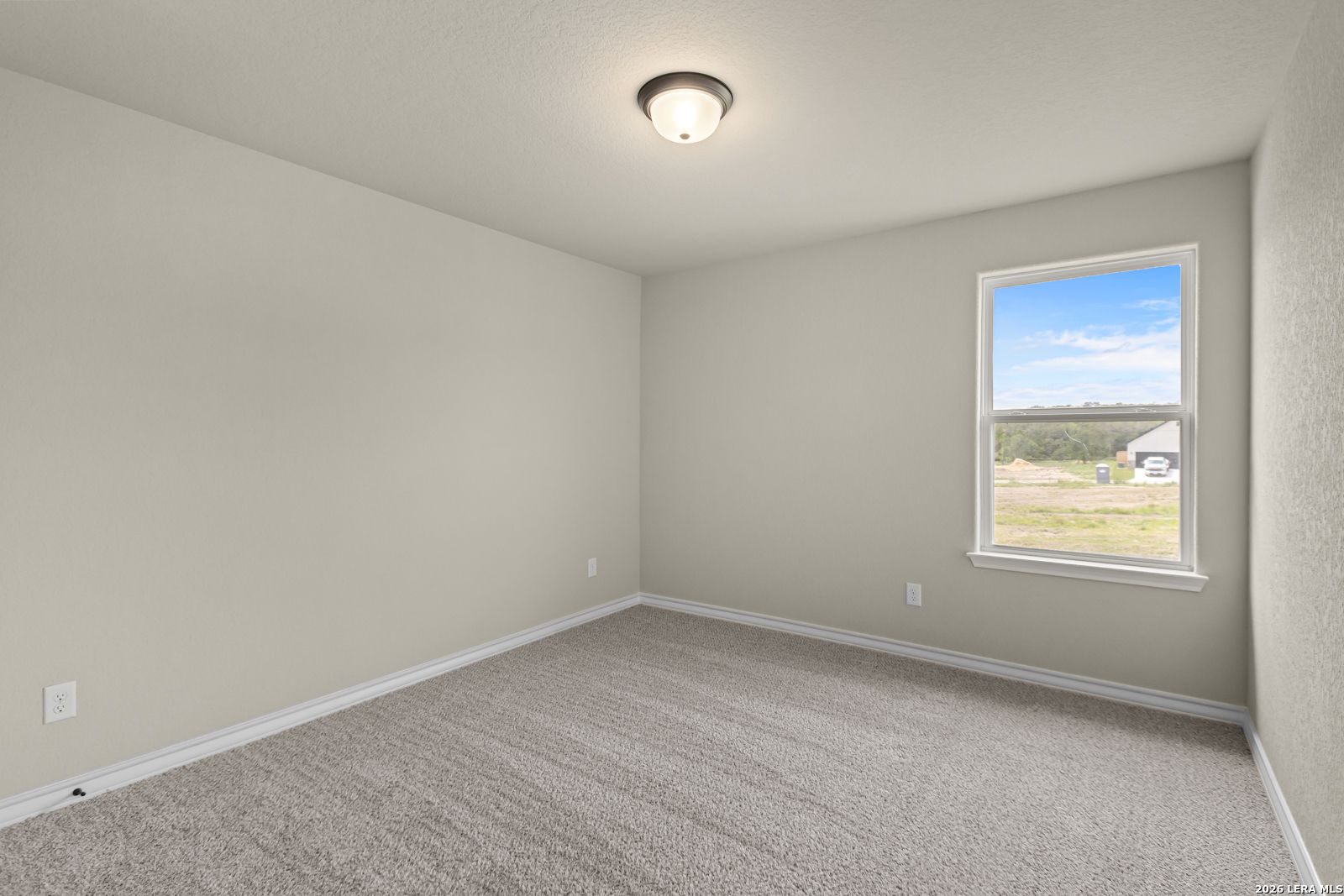Spacious secondary bedroom with neutral carpet and natural light in The Danbury H floor plan at The Reserve, Castroville.