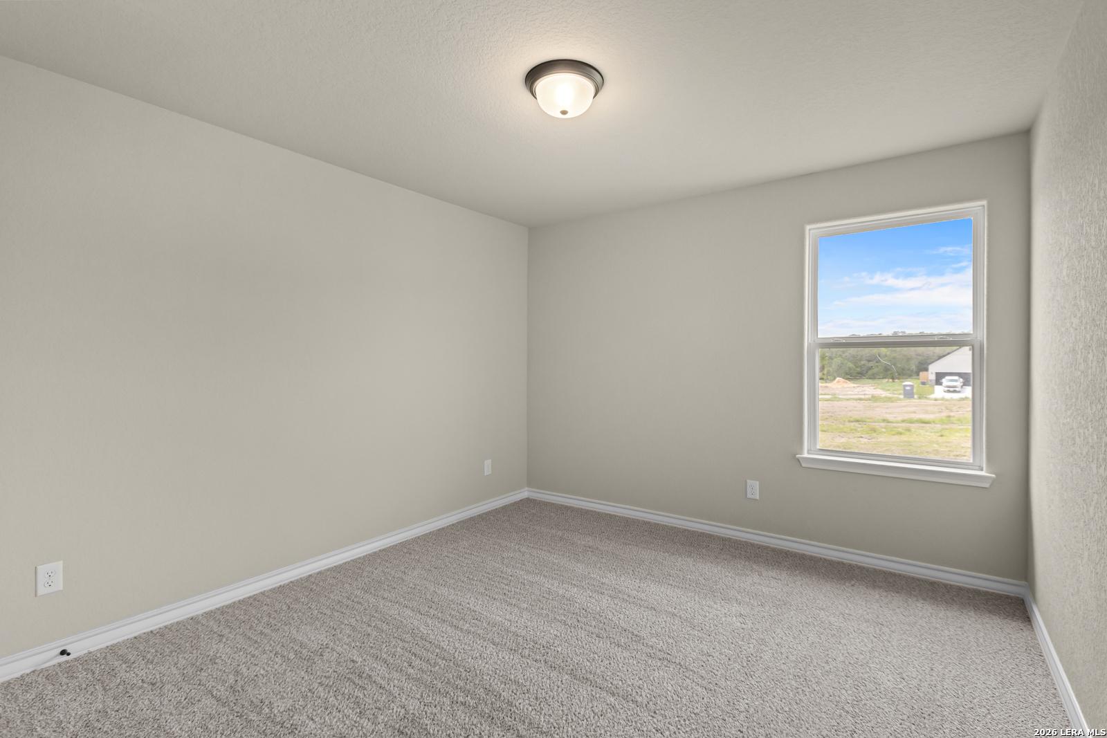 Spacious secondary bedroom with neutral carpet and natural light in The Danbury H floor plan at The Reserve, Castroville.