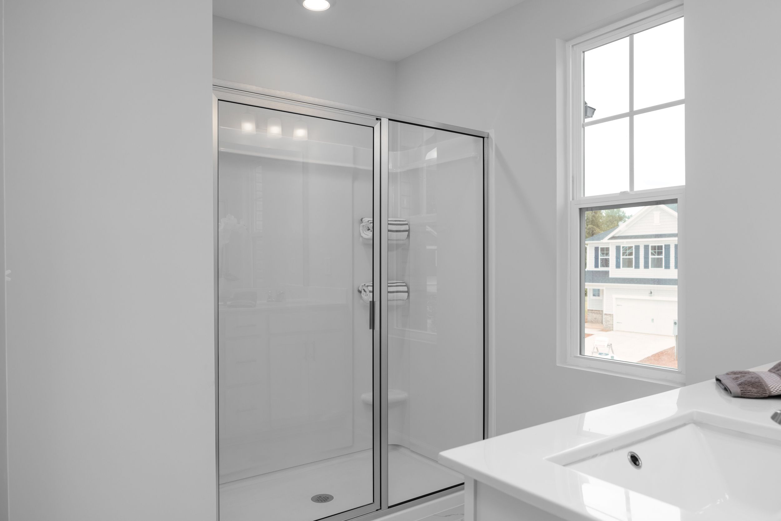 Modern glass-enclosed shower in the master suite of The Warren by Davidson Homes featuring a clean, minimalist design.