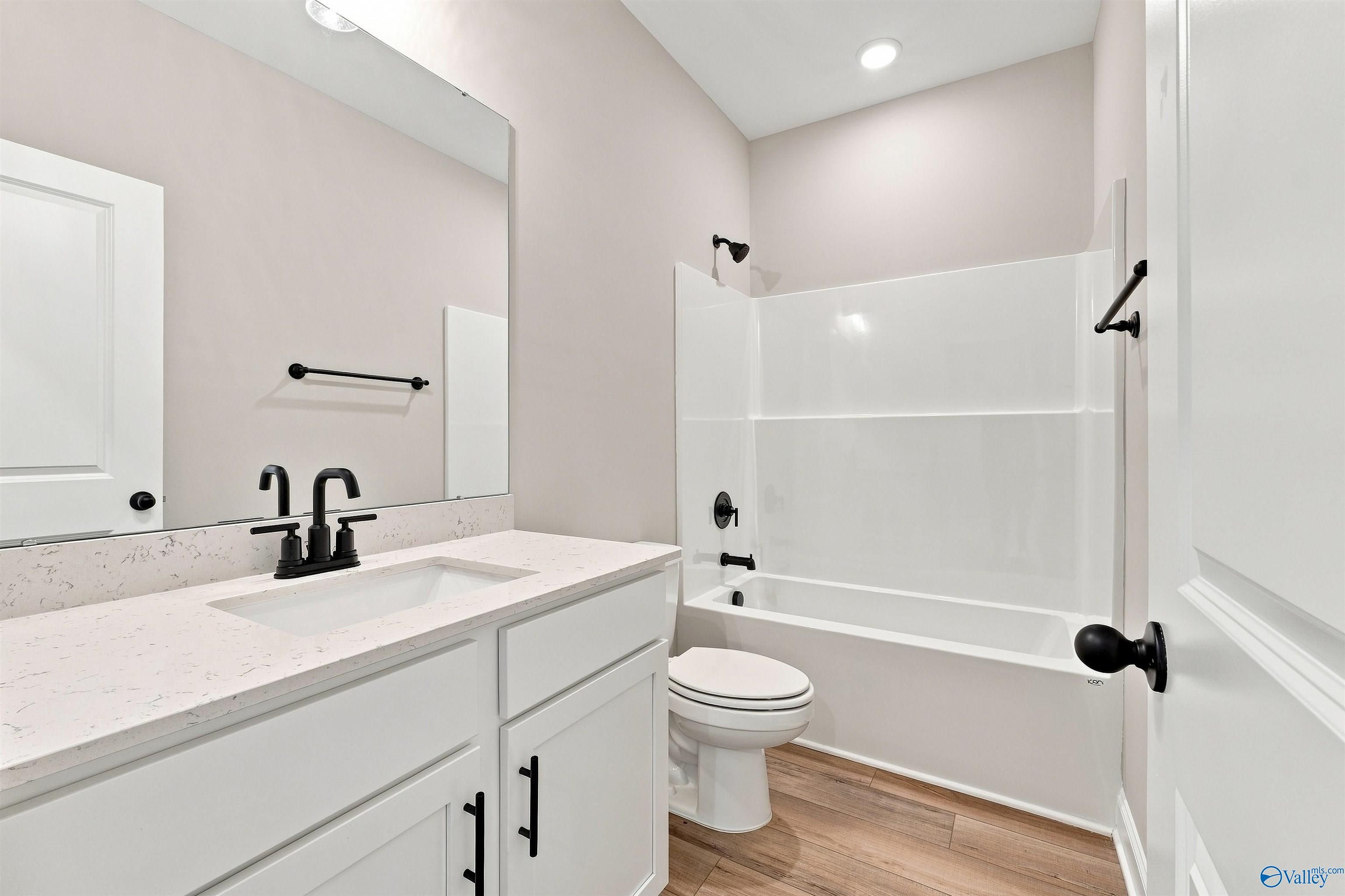 Modern bathroom with white vanity, black fixtures, and tub shower combo in Davidson Homes The Franklin C, Toney, Alabama