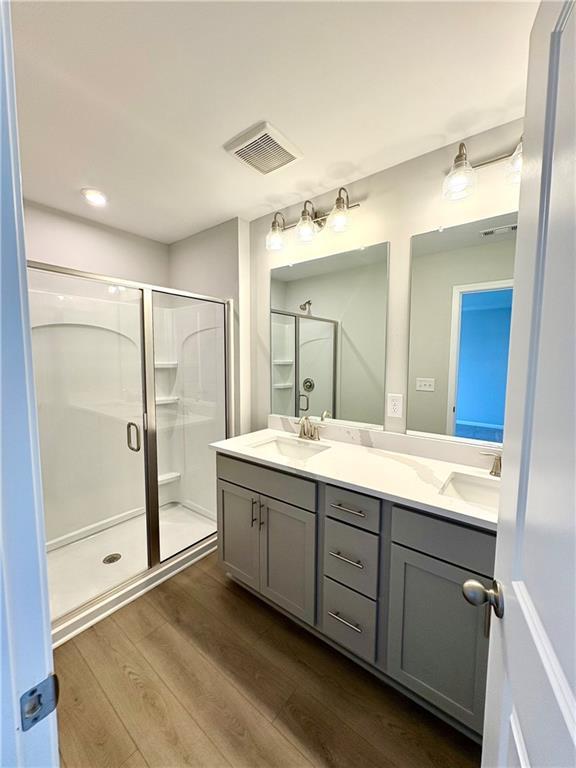 Modern master bathroom with double vanity, gray cabinets, frameless glass shower in Davidson Homes The Monroe A, Stegall Village, Emerson, GA