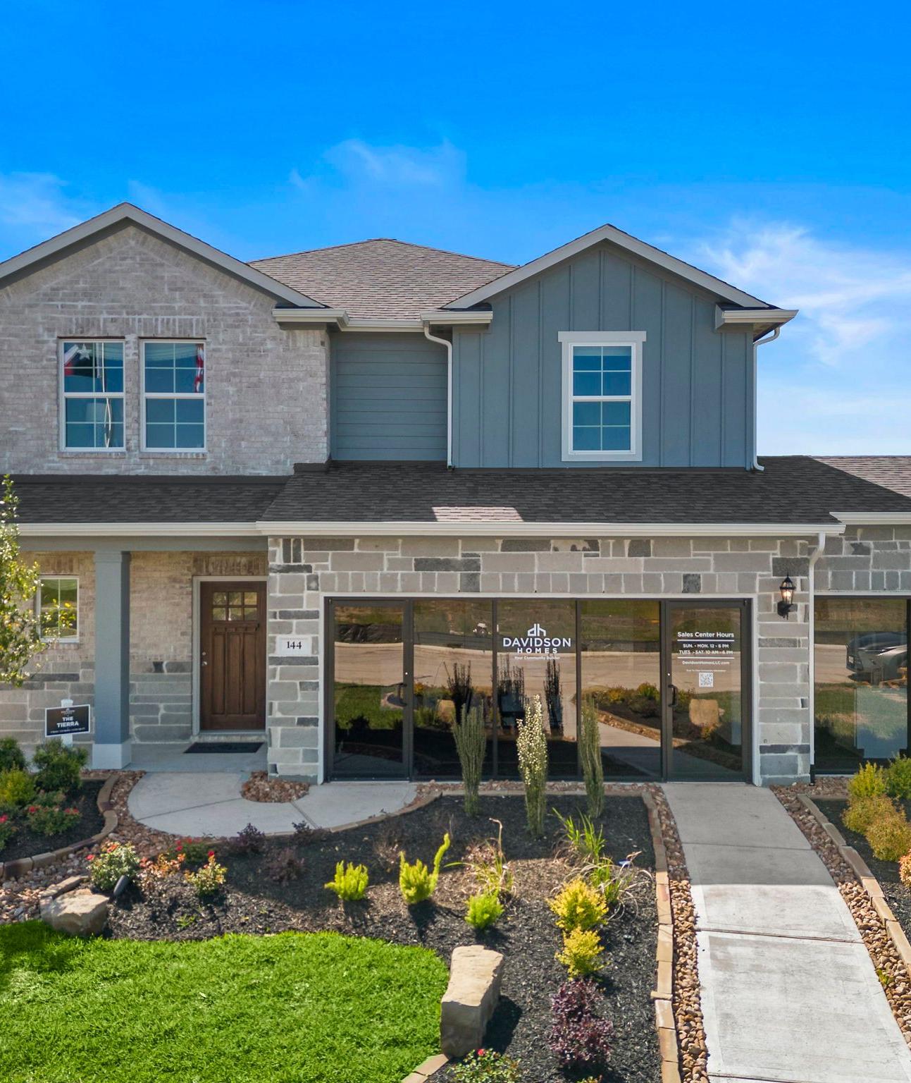 Spacious open-concept living room at River Ranch Meadows in Dayton Texas with modern gas fireplace, TV wall, cozy sofas and large potted plant