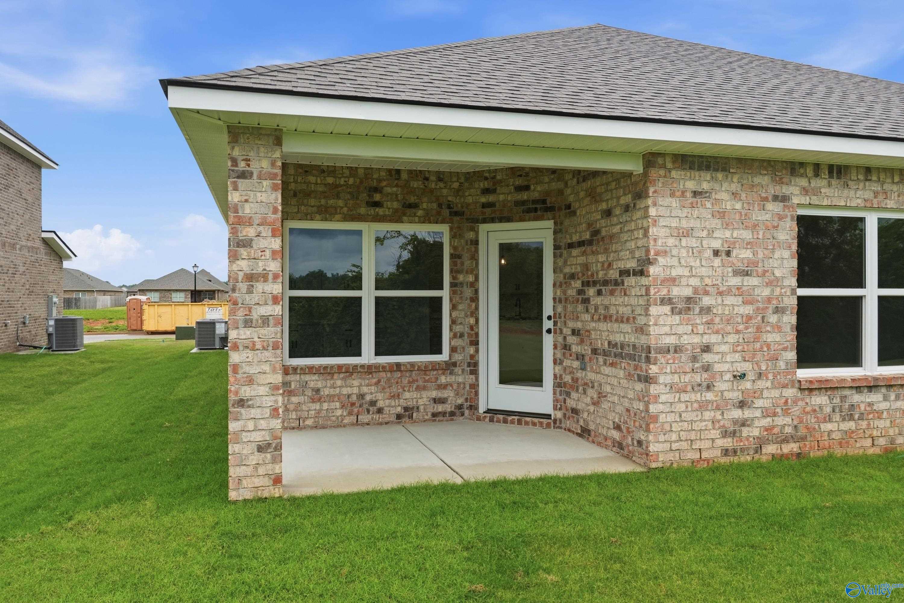 Brick exterior of The Daphne C floor plan by Davidson Homes featuring a covered patio in Ivy Hills, Toney, Alabama.