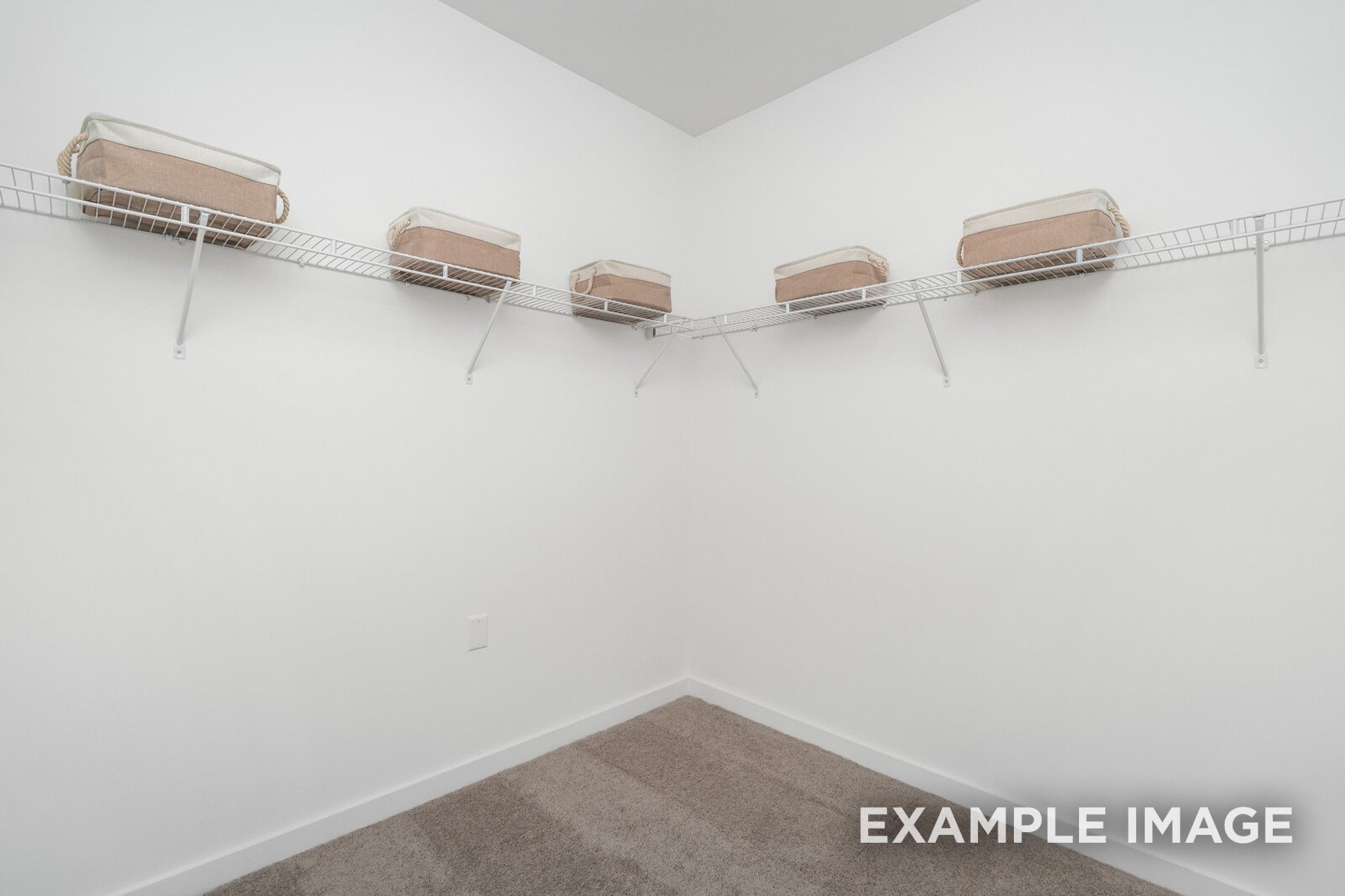 Spacious walk-in closet with wire shelving and beige storage bins in Davidson Homes The Ash A, Gallatin, Tennessee