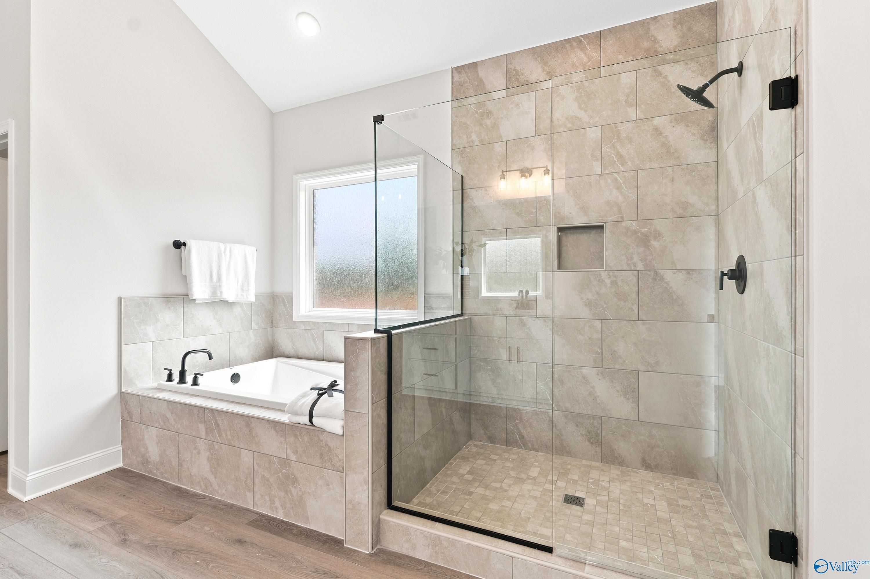 Modern master bathroom with soaking tub and tiled walk-in shower in The Finleigh by Davidson Homes, Riverton Preserve.