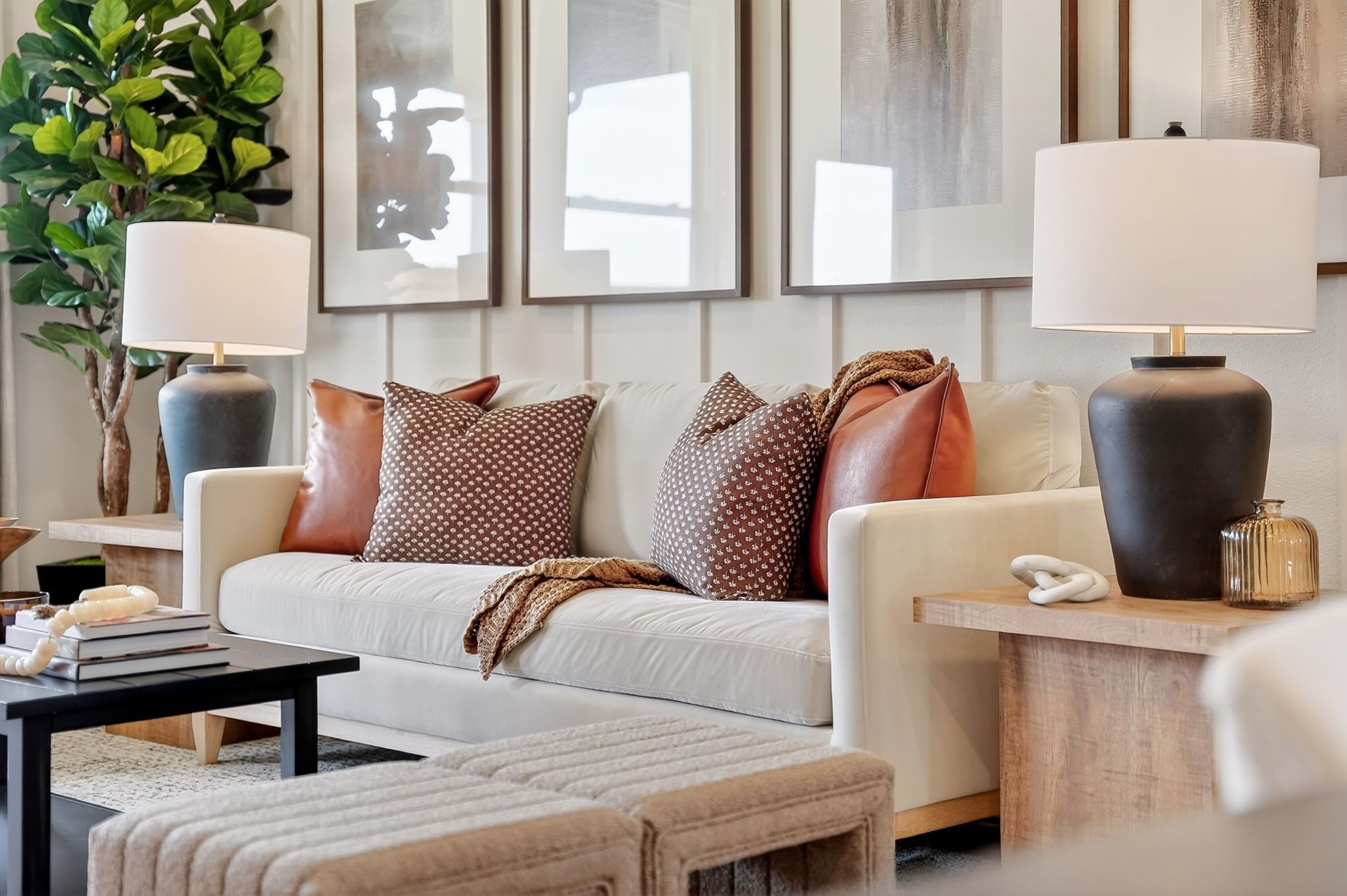 Modern living room with neutral sofa and decorative pillows in The Sabine J floor plan by Davidson Homes in Heartland, TX.