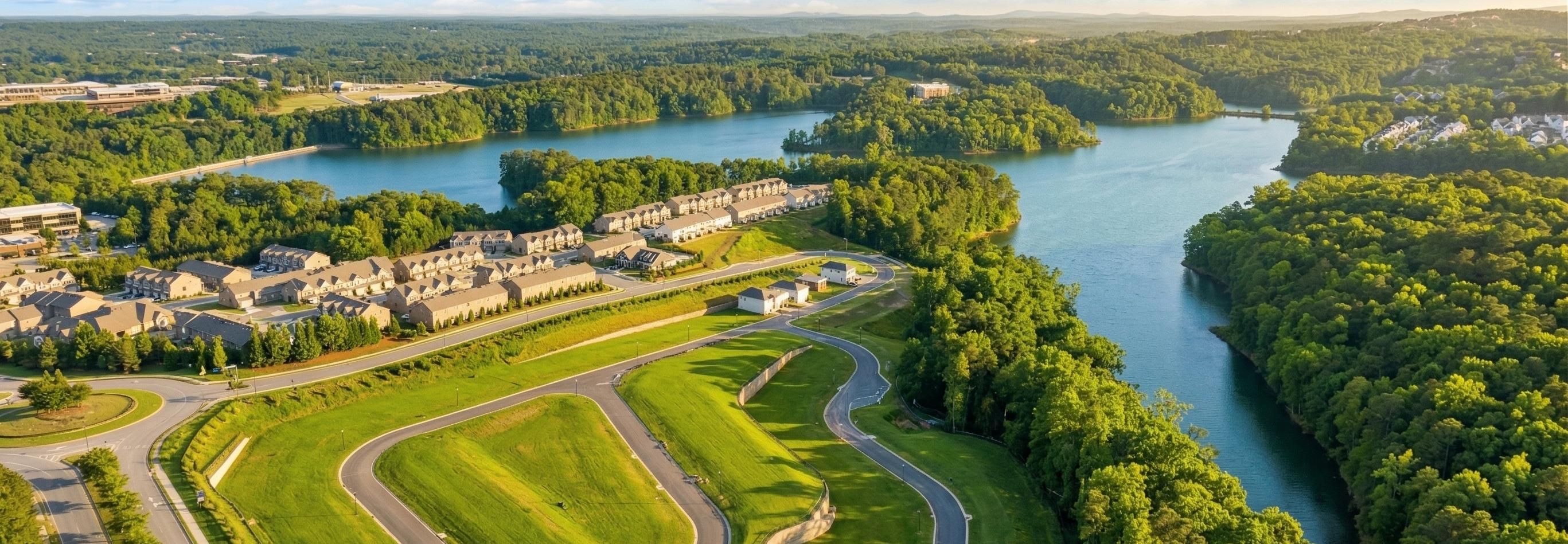 Spacious modern kitchen at The Bluffs in Canton GA by Davidson Homes with white cabinetry, stainless steel appliances, and island bar
