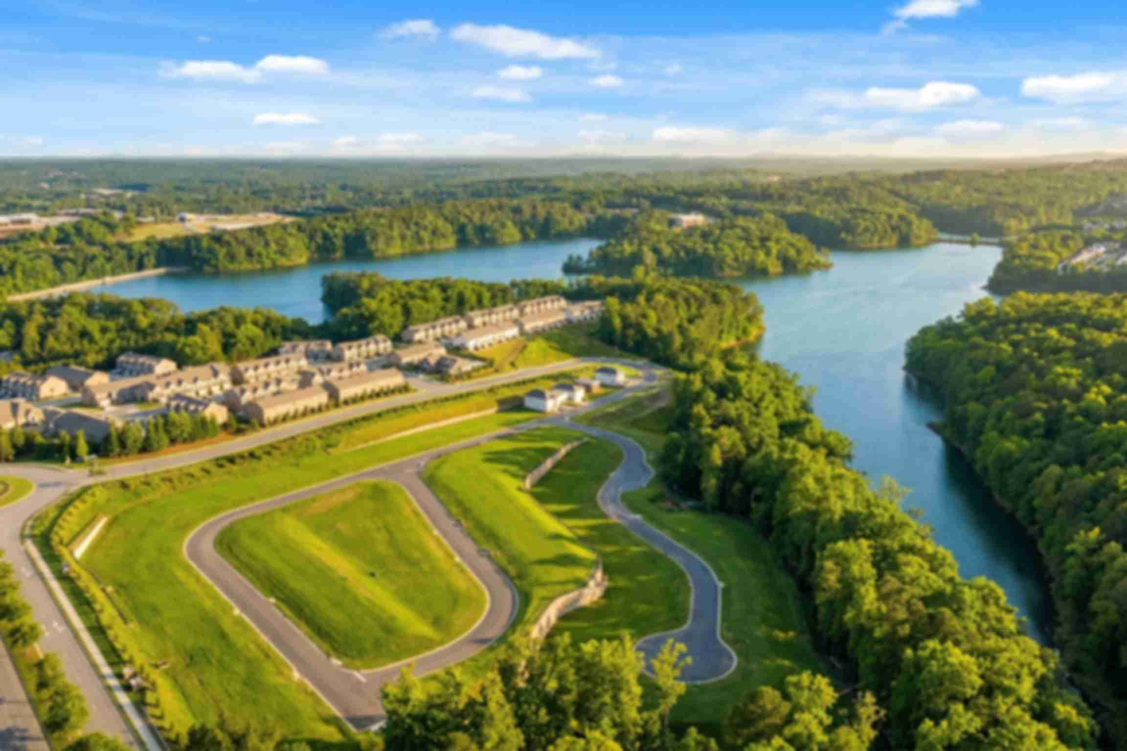 Spacious modern kitchen at The Bluffs in Canton GA by Davidson Homes with white cabinetry, stainless steel appliances, and island bar