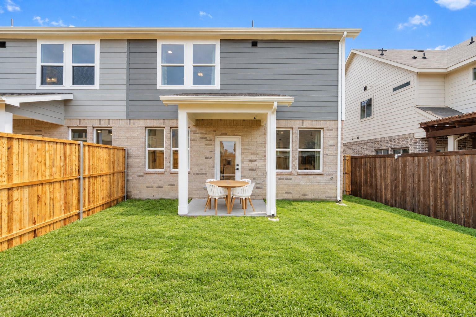 Covered patio with dining set overlooking fenced backyard at Davidson Homes The Wake C in Lake Park Villas, Wylie, Texas
