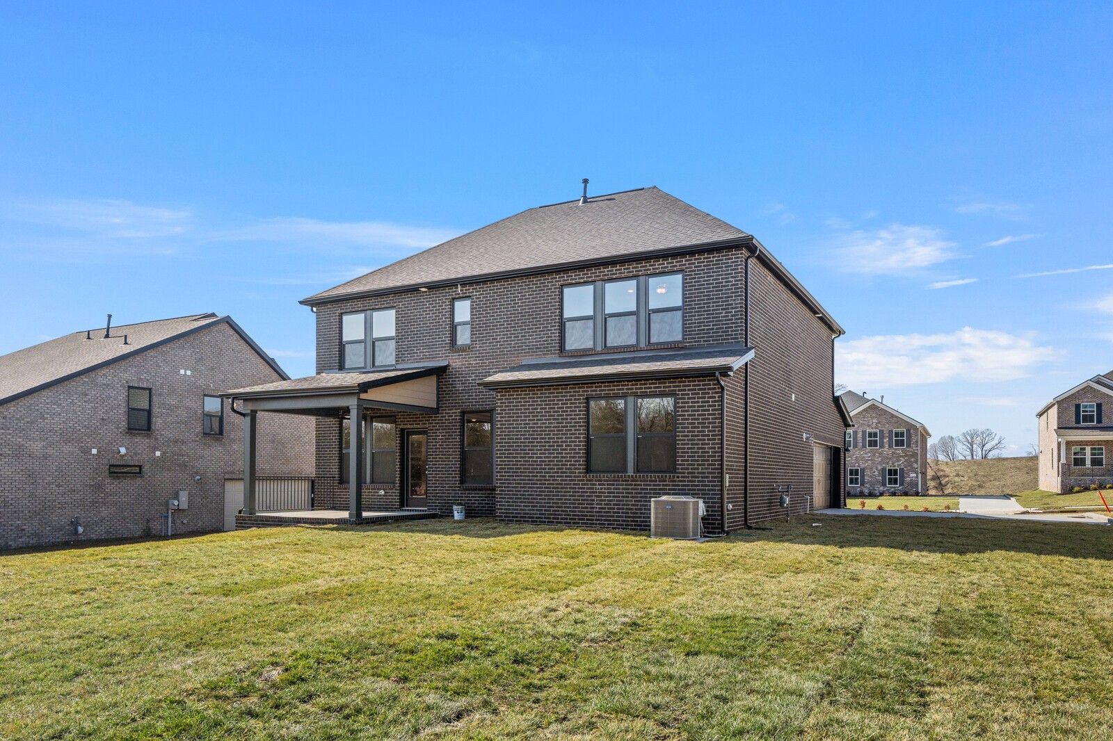 Two-story brick home with 2-car garage, covered patio, and grassy yard in Benders Cove, Mt. Juliet, Tennessee - Davidson Homes The Willow D
