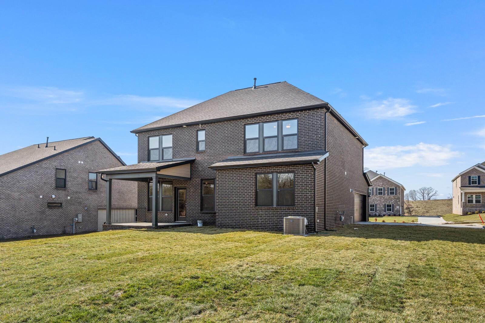 Two-story brick home with 2-car garage, covered patio, and grassy yard in Benders Cove, Mt. Juliet, Tennessee - Davidson Homes The Willow D