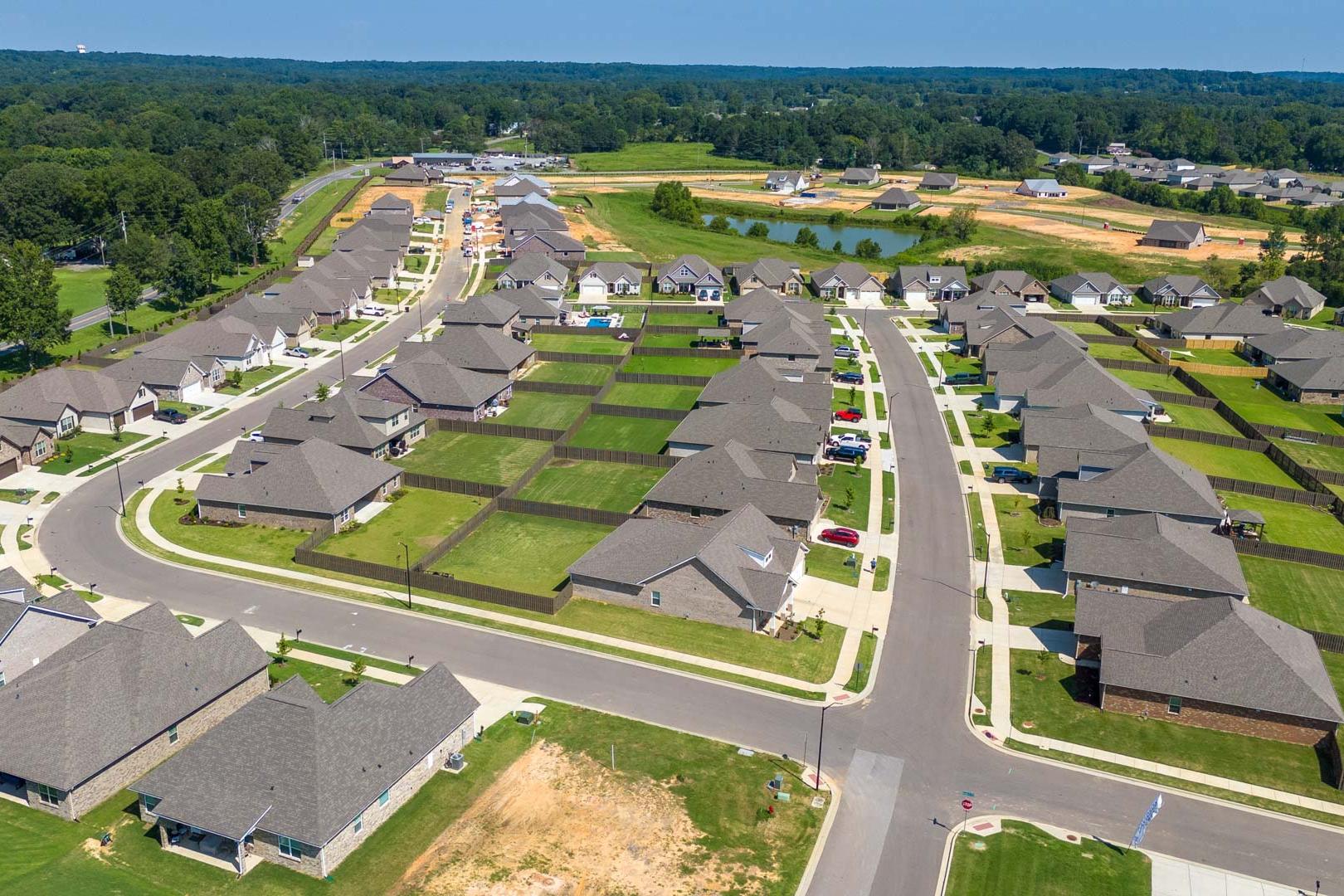 Aerial view of North Ridge neighborhood in Cullman Alabama featuring new Davidson Homes with gabled roofs green lawns and pond