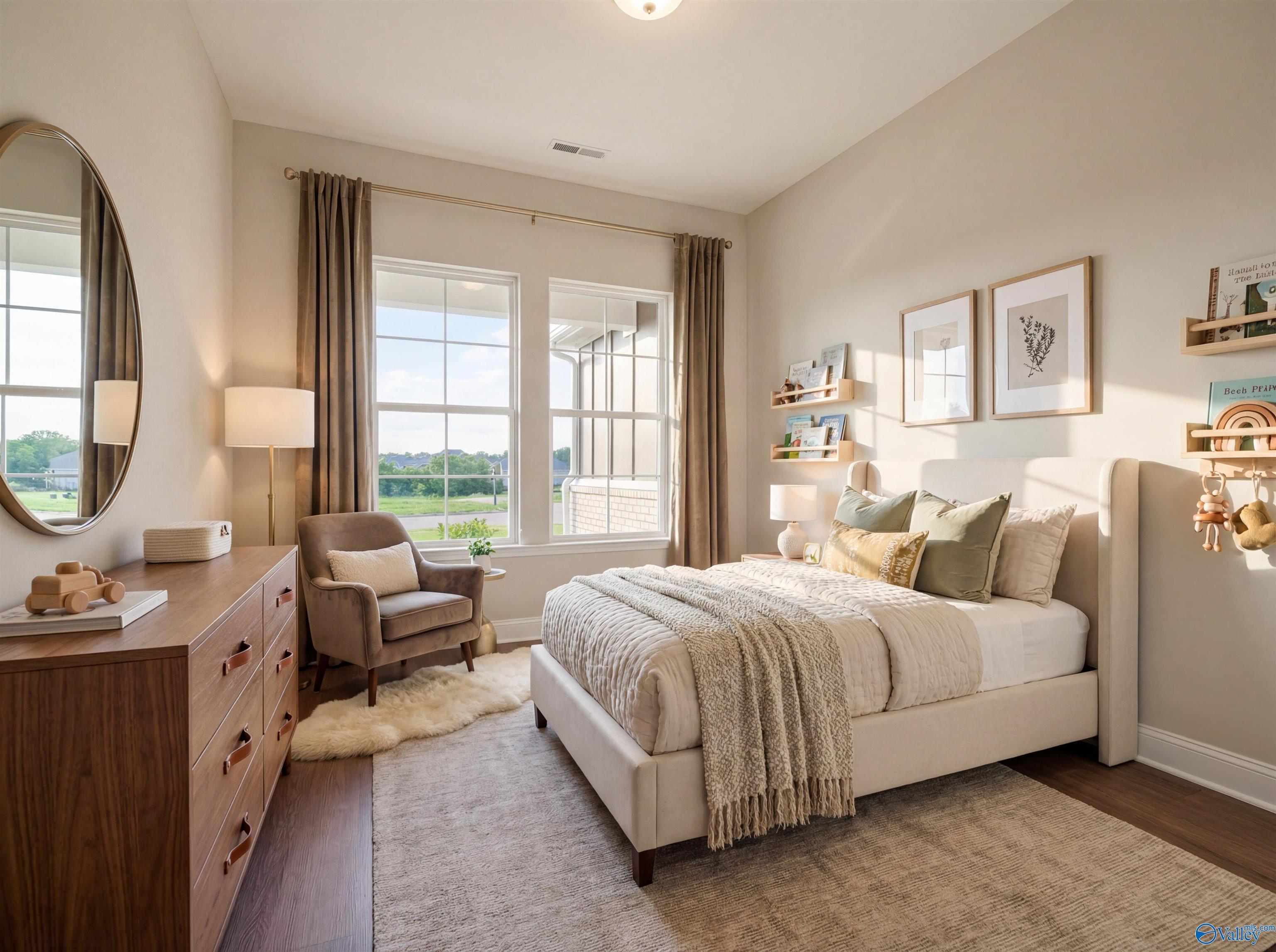 Serene neutral bedroom with plush bed, wooden dresser, armchair, round mirror, toy shelves, and large windows in Davidson Homes The Arcadia B, Huntsville
