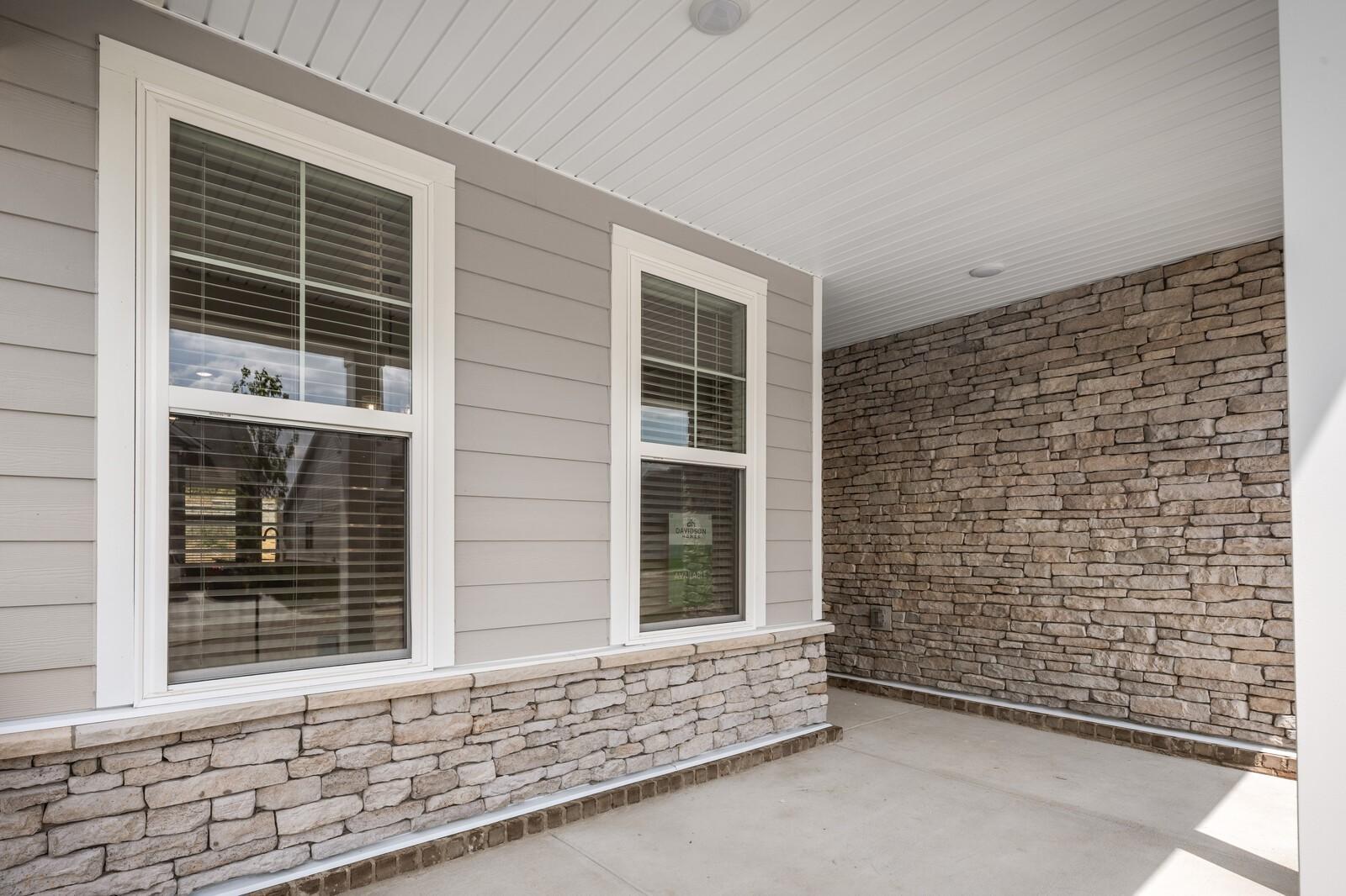 Covered front porch with stone accents and siding on The Willow floor plan by Davidson Homes in Gallatin, Tennessee.