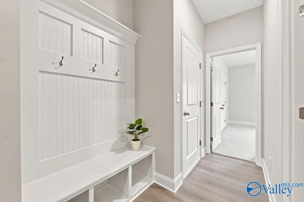 Built-in mudroom bench with coat hooks and beadboard paneling in Davidson Homes The Harrison, Hartselle, Alabama