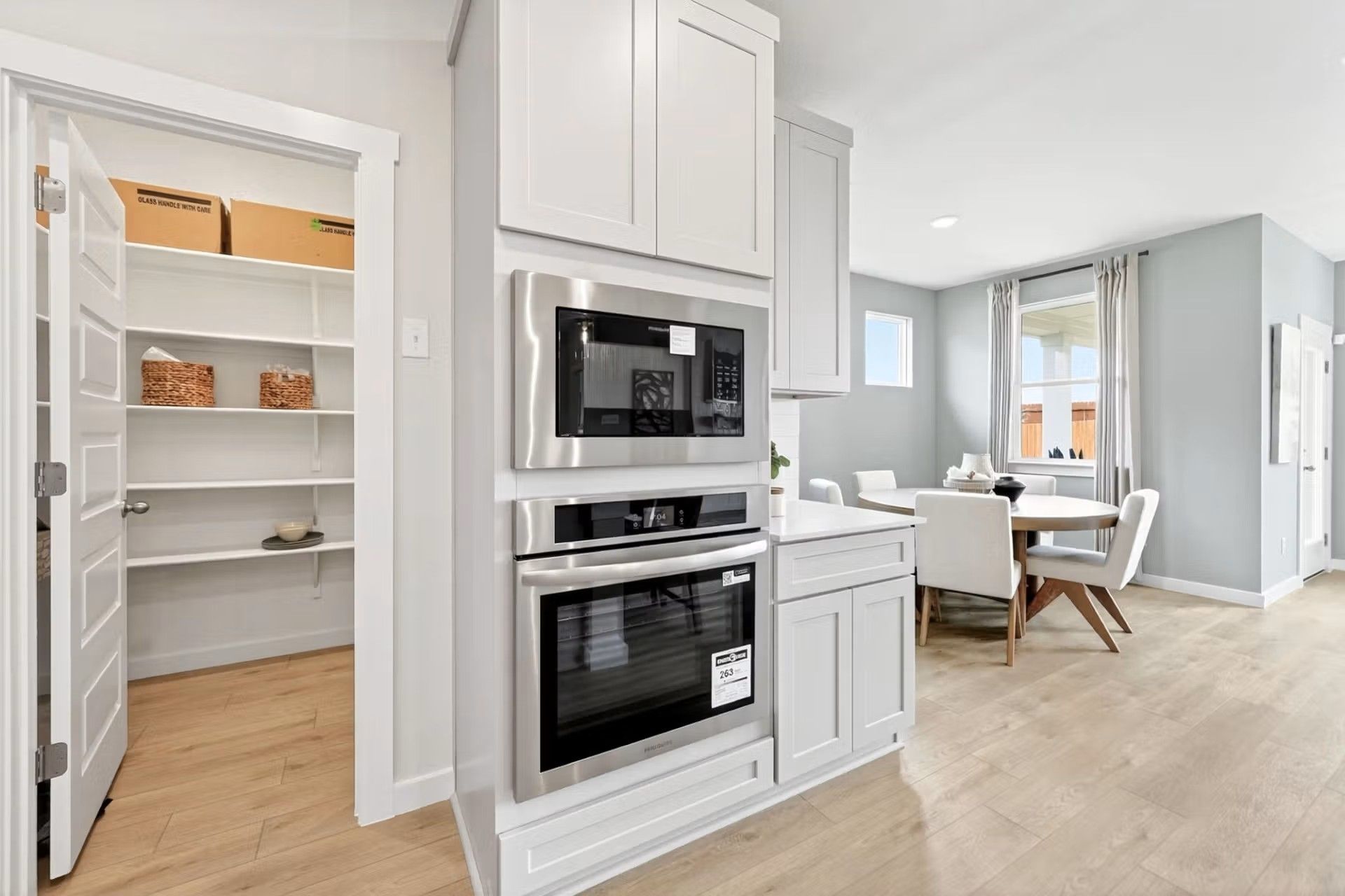 Modern kitchen with stainless wall oven, microwave, and walk-in pantry in The Laurel I floor plan by Davidson Homes.