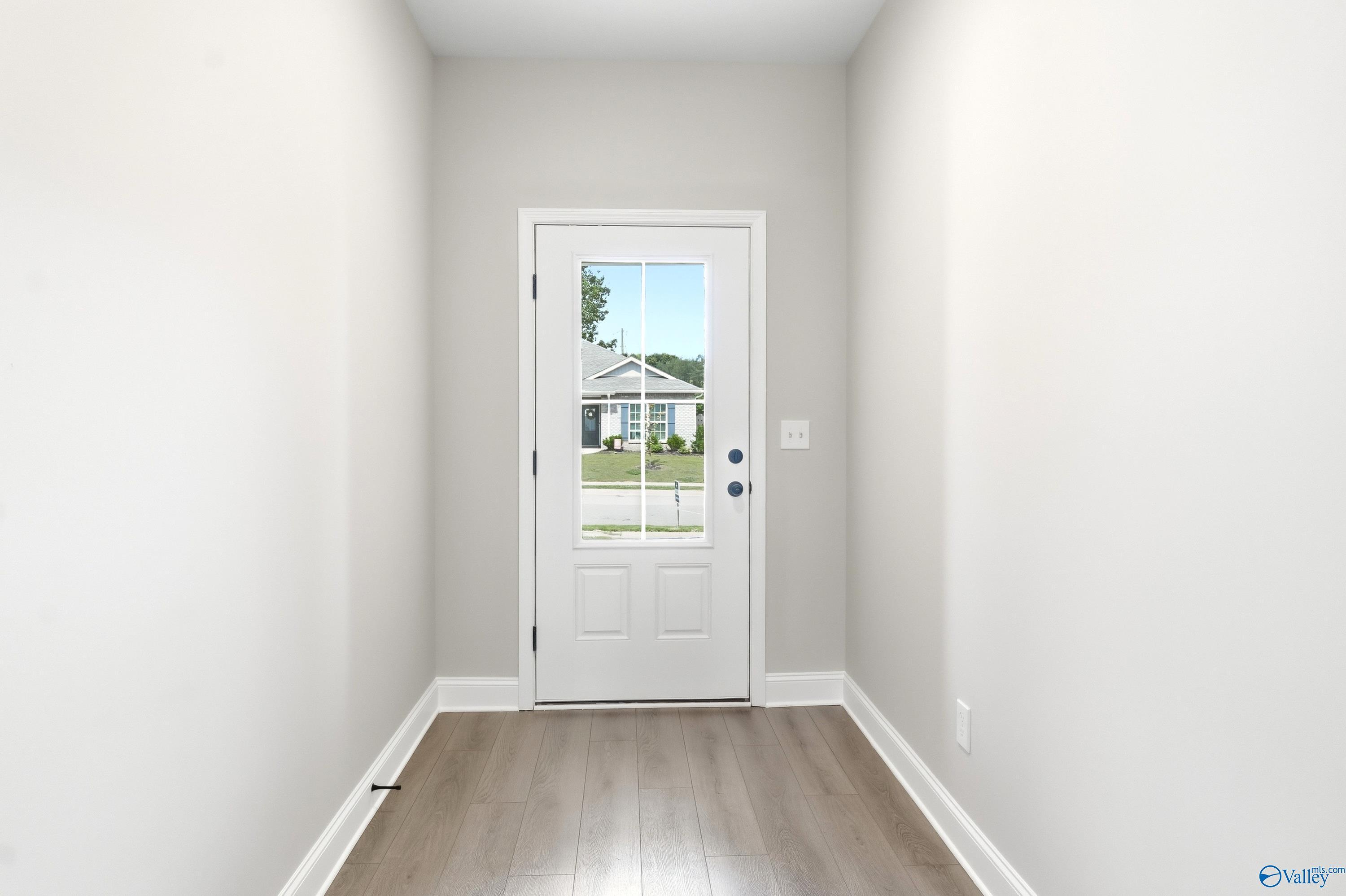 Bright entryway with light hardwood floors and glass-paneled front door in The Daphne C home, Flint Meadows, New Market.