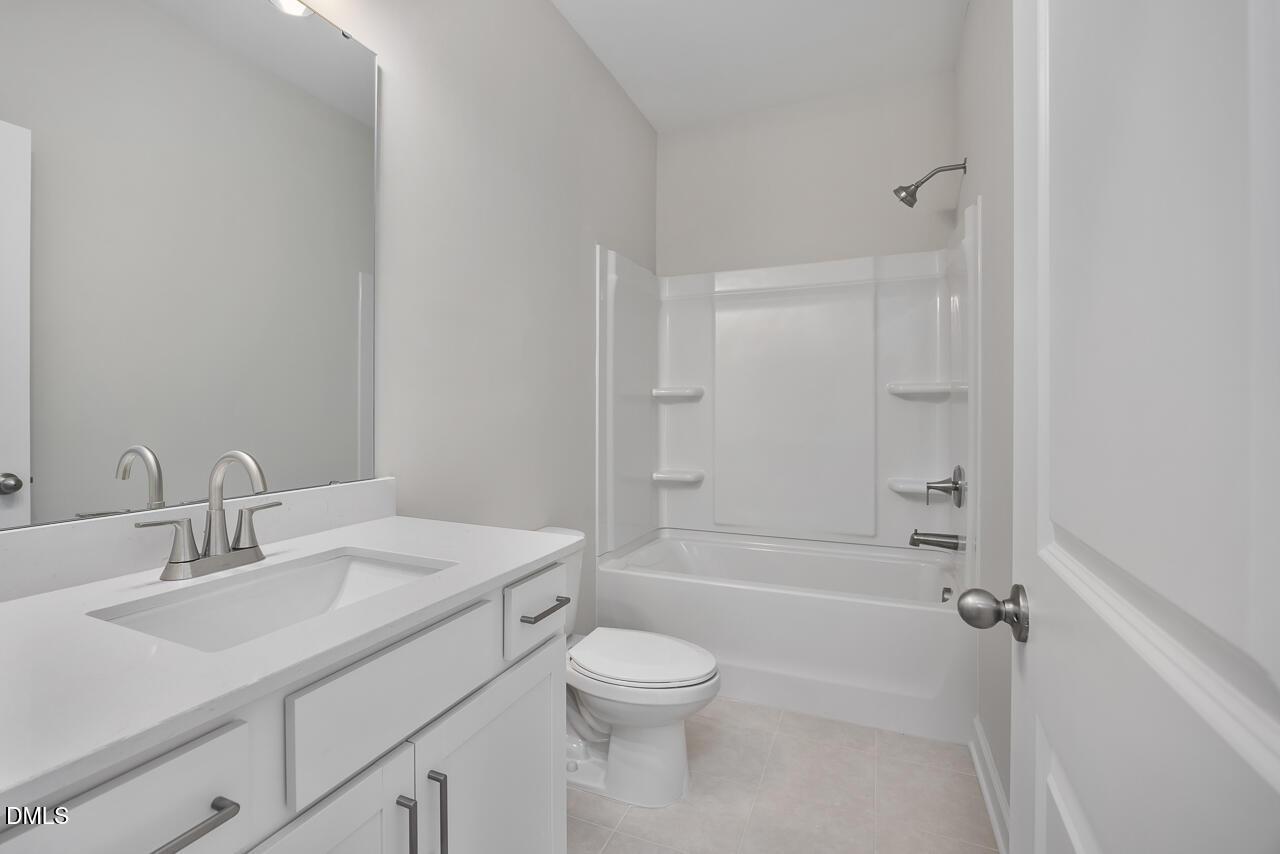 Modern bathroom with double vanity, soaking tub, shower combo, and toilet in Davidson Homes The Daphne C, Lillington, NC
