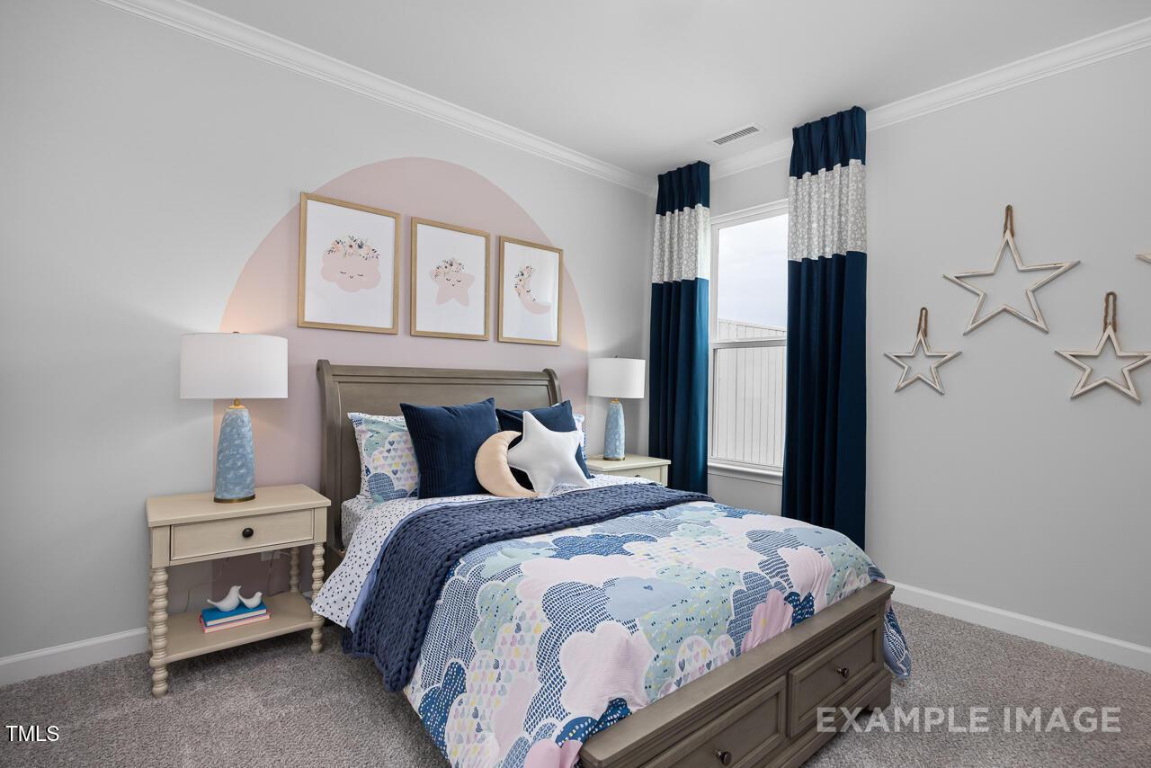 Whimsical girl's bedroom with cloud-patterned bedding, blue curtains, star decor, and arched pink wall art in Davidson Homes Magnolia B, Angier, NC