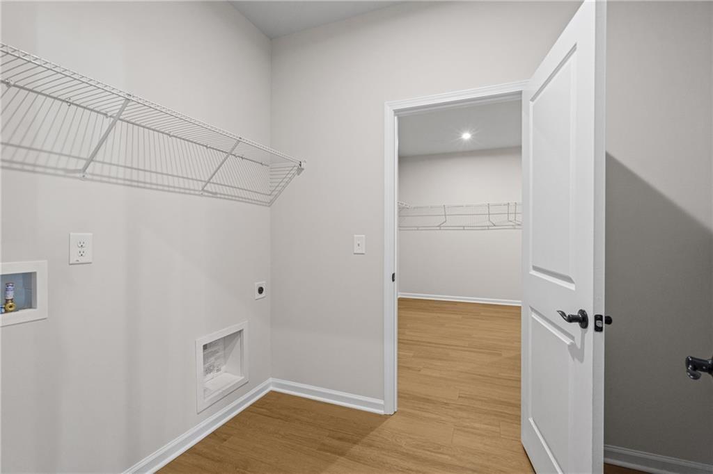 Functional laundry room with wire shelving, washer-dryer hookups in Davidson Homes The Edison B, Kelly Preserve, Loganville, GA