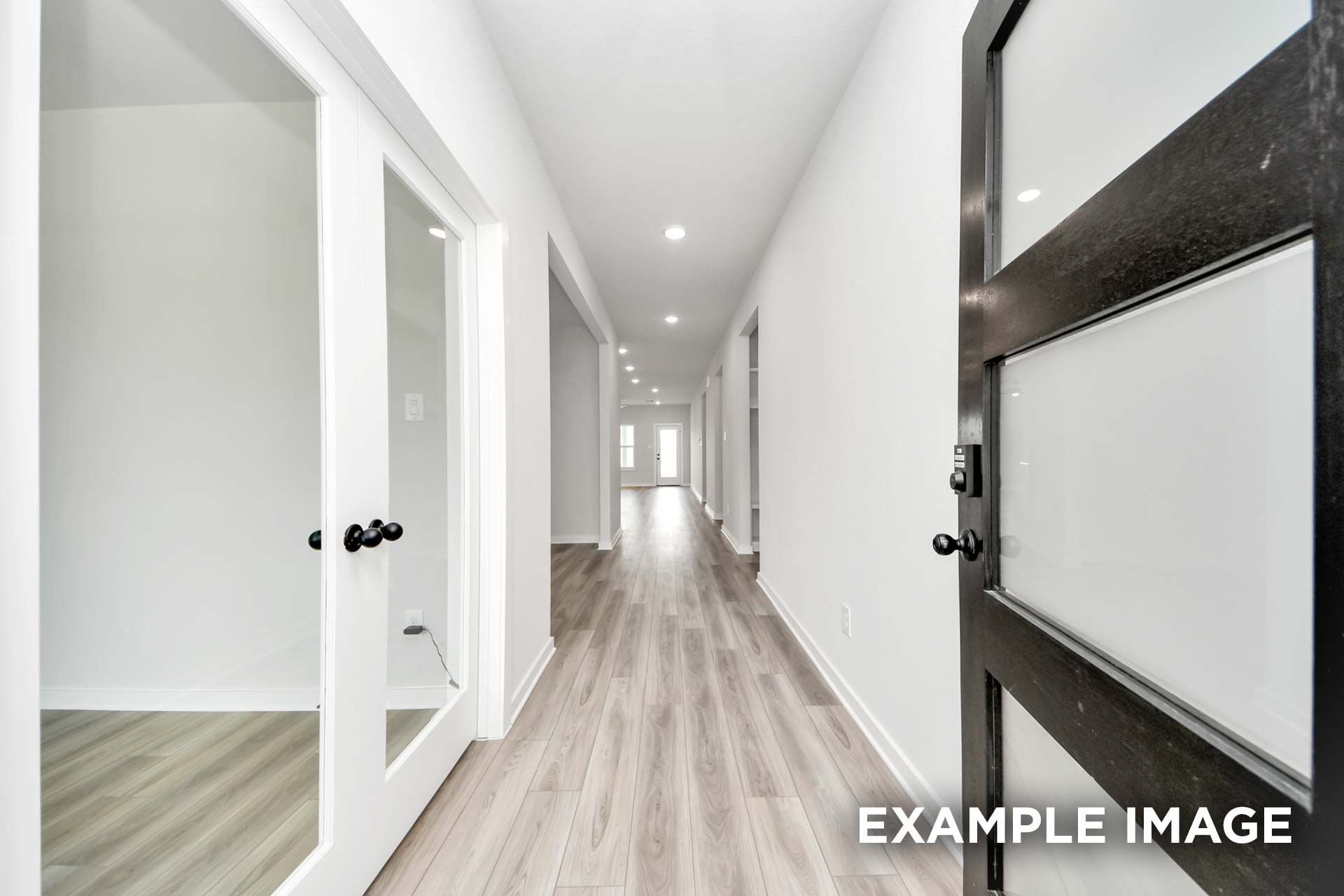 Bright hallway in The Sorrento home design featuring modern wood-look flooring and glass-paneled interior doors.