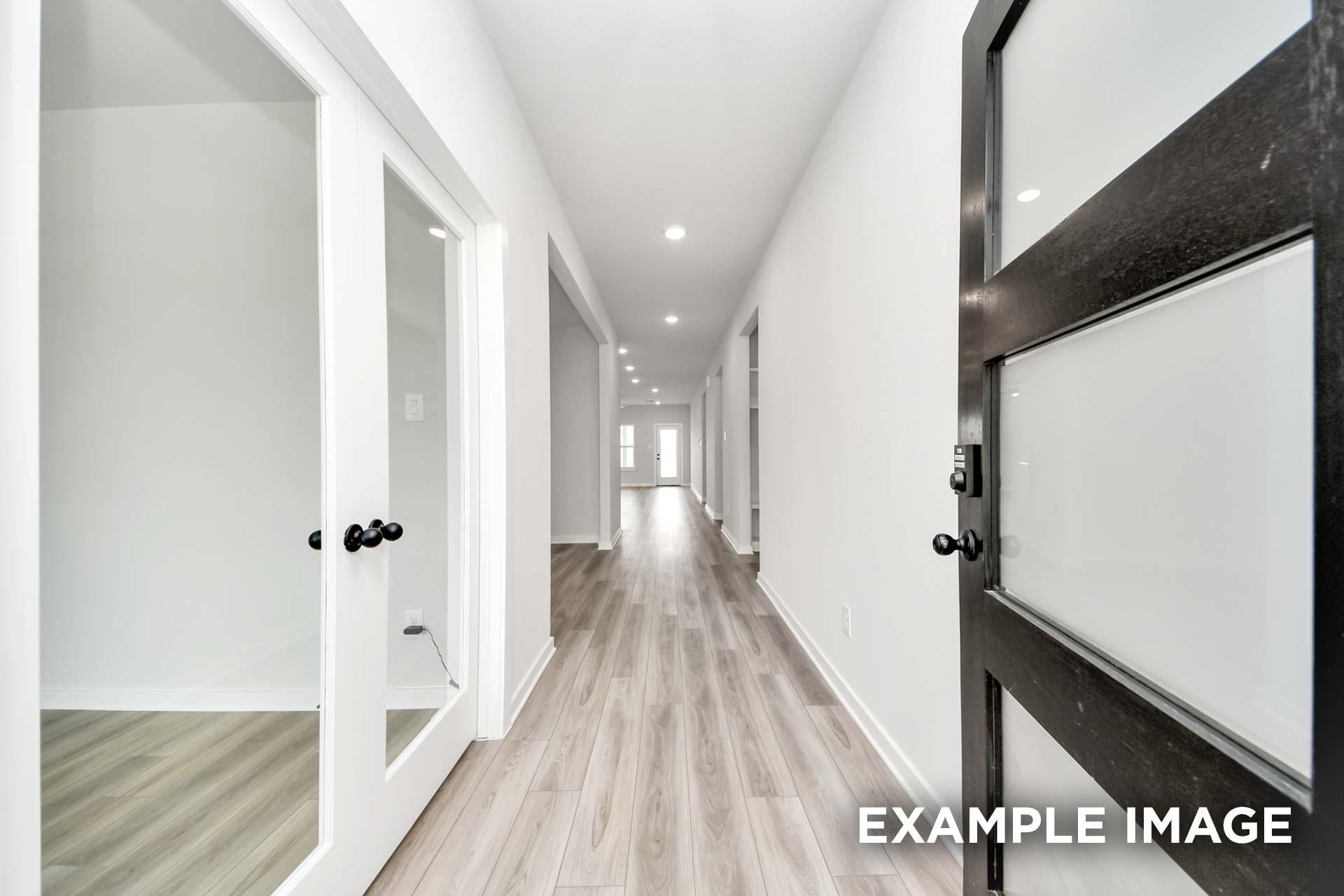 Bright hallway in The Sorrento floor plan featuring light wood-look flooring and modern glass-paneled doors.